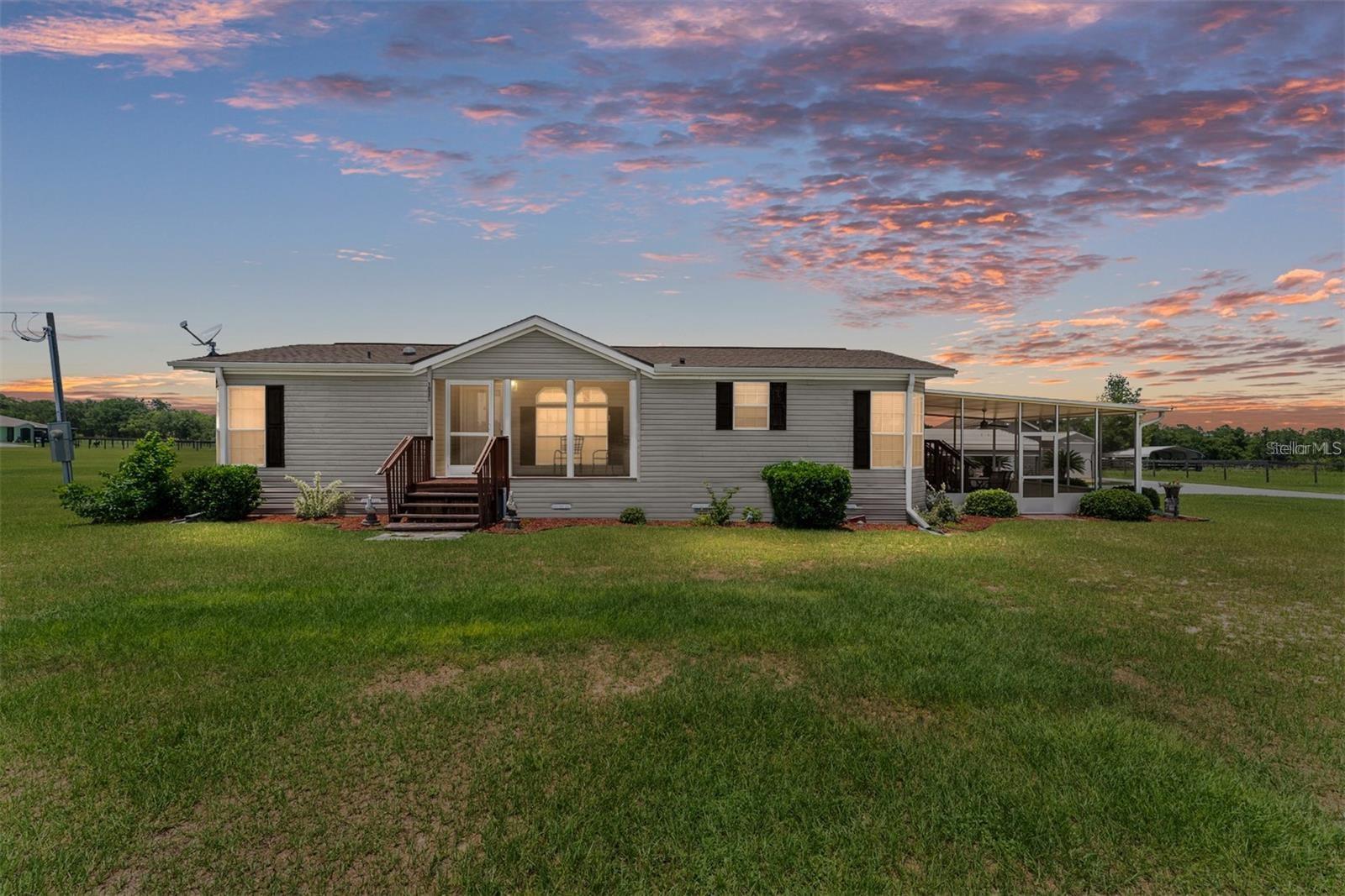 MOVE IN READY!! Country living at it's finest. Peaceful and private, yet minutes to The Villages and all it has to offer. Zoned A-1/
General agriculture, cleared and green pasture! Well kept, 3/2 with newer counter tops. Refreshed guest
bath, comfort height toilets, and solar tube for plenty of light! This home has indoor laundry and a nice sized pantry. A/C 2019
and Roof 2017 Nice screened in front porch to enjoy your evening coffee, and a large (20 x20) screened patio for family and
friends to gather! Detached work shop w/electric and wall unit A/C and an additional storage shed. Newer Zero-turn mower
available for sale separately. Call today for a private viewing!