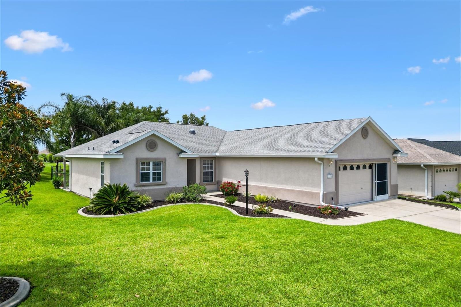 Under contract-accepting backup offers. Welcome to your Forever home in the desirable 55+ Gated Golf Community of STONECREST, where comfort, convenience, and community come together. Ideally located just off US 27/HWY 441 and adjacent to THE VILLAGES, Florida, this beautifully maintained 3 Bedroom, 2 Bath Sycamore model is being offered turn-key, just bring your personal items and move right in. Inside, you'll find NEW LAMINATE flooring throughout, adding a fresh, modern touch. The open living space flows effortlessly to the lanai, complete with an added custom sunshade creating a perfect setting for relaxing or entertaining. Sliding doors from both the living room and the primary suite with easy access to the outdoor space, while a portion of the backyard is fenced, making it ideal for your furry friends. This home has been updated with a NEW ROOF (2022), NEW HVAC (2017), and NEW GARAGE DOOR OPENER (2025). The professionally landscaped yard adds to the home's curb appeal, and the sliding screen over the garage door is a charming and practical touch. Living in STONECREST means enjoying access to top-tier amenities in a warm, welcoming environment designed for active adults. If you’re ready to embrace the retirement lifestyle you’ve been dreaming of, this home is ready to welcome you.