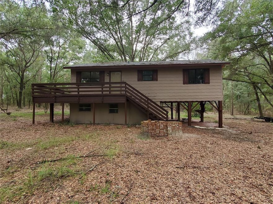 Peaceful home in the woods.  This quaint 2/2 in Gilchrist county sits on 10 wooded acres, away from all the hustle and bustle!  Laminate floors throughout.  Spacious wooden deck overlooks the property.  Storage and carport on the bottom, living space on top.  Storage shed on site, fenced, and ready to move in.  Call today!