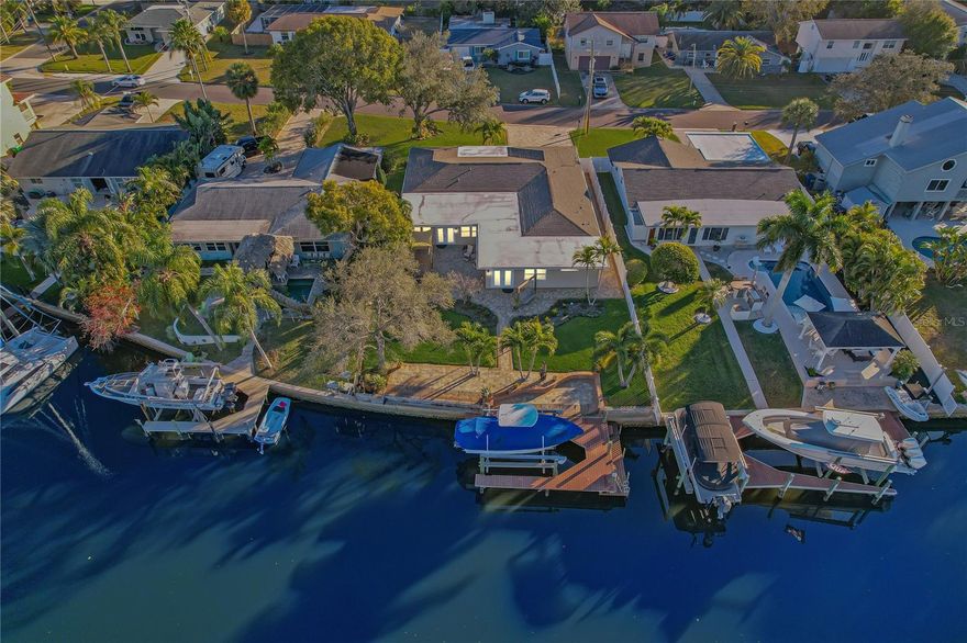 Welcome to this Modern Coastal waterfront home located in the highly desirable Baywood Village community of Palm Harbor. This home offers direct Gulf access with No Bridges via the Only Deep Water Canal in all of North Pinellas County, making this a True Boaters Dream to come and go anytime of day! Designed for effortless Florida living, this property features a composite dock with electric and a 13,000 lb boat lift, making it easy to enjoy boating straight from your backyard. The fully fenced outdoor space is ideal for relaxing and entertaining, complete with a built in fire pit, seating area, outdoor grill and outdoor LED Landscape Lighting offering a multitude of colors to create the perfect ambiance, all overlooking peaceful water views.

Inside, the home showcases a stunning kitchen with an expansive island featuring built-in storage, coastal tile backsplash, Quartz countertops, solid wood white cabinetry, pull-out drawers, stainless steel appliances and a wine fridge. New Hurricane Impact Resistant windows! Life proof luxury vinyl plank flooring runs throughout the main living areas, complemented by porcelain tile in the bathrooms. The open living room flows seamlessly to the backyard through the french doors, creating a true indoor/outdoor lifestyle, while a beautifully placed dining area sits at the heart of the home. The split bedroom floor plan offers privacy, with a well appointed primary suite with a boutique style, custom closet system with Island, you have found your Dream Closet! And Fully Customized Closet Organizational systems in ALL Closets, maximizing every square inch! Two sunrooms ~ one at the front and one at the back, adding flexible living options and would make excellent office or bonus spaces. Additional built-in outdoor storage provides room for water toys and equipment. Everything here has been completely remodeled and 100% up to Current County Codes, including all electrical and plumbing. The boat is available for purchase separately.

Baywood Village offers an unbeatable location close to downtown Palm Harbor, Ozona and the Tarpon Springs Sponge Docks. Enjoy quick access to nearby islands including Anclote, Honeymoon, Caladesi and Three Rooker, along with local beaches like Fred Howard Park and Sunset Beach. Golf lovers will appreciate proximity to Innisbrook Resort’s Copperhead Course, along with other area golf clubs. The Pinellas Trail is just outside the community and Tampa International Airport, St. Pete-Clearwater International Airport and Clearwater Beach are all within easy reach. This waterfront home delivers the best of coastal living with comfort, style and location. Start Living Your Best Florida Lifestyle Today! Make Your Waterfront Dream a Reality!