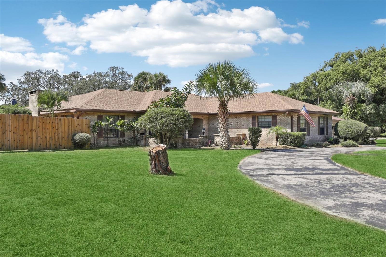 One or more photo(s) has been virtually staged. One or more photos have been virtually staged. Welcome to your new Pool Home with NO HOA! This charming brick house sits on a roomy just over a quarter-acre corner lot with a circular driveway — plenty of space for guests to park when friends and family come by. Inside, you’ll love the open split floor plan that makes it easy for everyone to spread out while still feeling connected. The cozy stone fireplace is the heart of the living room and just steps away you’ll find the bright sunroom/lanai, perfect for family game nights, morning coffee, or watching the kids play in the pool. The 520 sq. ft. screened Florida room gives you tons of extra space to relax or entertain, rain or shine. The primary bedroom is private and comfortable, featuring its own bathroom and two closets, while the split layout keeps the other bedrooms separate — ideal for kids’ rooms, a home office, or guest space. The large, fenced backyard gives you peace of mind for kids and pets, and the side gate makes it easy to pull in a trailer or store toys like bikes and kayaks. Other perks you’ll appreciate: New Roof (2024), bring your boat, RV, or other big toys! Conveniently located minutes away from entertainment such as Lake Square Mall, Restaurants, and the Harris Chain of Lakes!