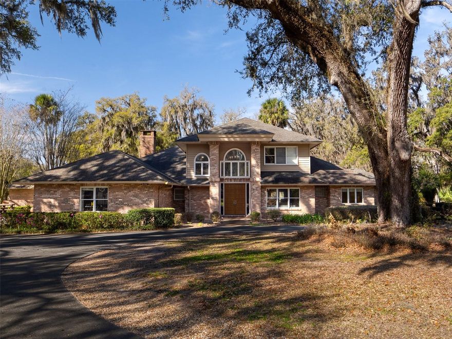 Set on 10 acres in the heart of Ocala, this estate is just 10 minutes from the Florida Horse Park and historic downtown Ocala, with its shops, restaurants, and local amenities. The property is also near the Florida Greenway trails, ideal for riding, walking, or simply enjoying the outdoors. A concrete circular driveway welcomes you to a stunning two-story brick home offering 5 bedrooms and 5.5 bathrooms. The primary suite is a private retreat, complete with a large soaking tub, spacious walk-in shower, dual sinks, and a vanity. Throughout the home, high ceilings, walk-in closets, an office/den with a wood burning stove, a great room, and a living room create a sense of space, elegance, and comfort. The gourmet kitchen boasts an island with ample storage, updated appliances, a breakfast nook, and a formal dining room with French doors opening to the covered back porch and in-ground pool. A large laundry room and 2-car garage add convenience and functionality. The property also features a 4-stall block center-aisle barn with tack and feed rooms, a round pen, a clay riding arena, and run-in sheds. A small pond with a dock enhances the landscape, while mature trees provide shade and natural beauty for both you and your horses. This exceptional estate combines refined luxury, premier equestrian facilities, and a serene country setting, creating a truly one-of-a-kind Florida lifestyle.