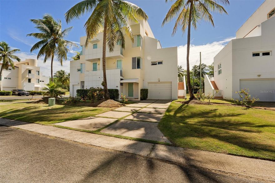 Located in the gated community of Villas de Golf in Dorado, this corner villa is available for rent fully furnished and move-in ready. The property provides privacy and convenient access to the community’s amenities. The villa is distributed across four levels connected by a private elevator. It offers multiple living areas, a kitchen, four bedrooms each with its own bathroom, and an additional half bathroom. It also features an enclosed garage, extra parking spaces, 20 solar panels with transfer switch, and a water cistern. Villas de Golf is a secure community with 24/7 access control. Residents enjoy a swimming pool, tennis and basketball courts, gazebos, a playground, and landscaped green areas. The community is next to the golf course and close to Embassy Suites by Hilton Dorado del Mar Beach Resort, as well as restaurants, a bowling alley, and a karting track. Beaches, schools, shopping centers, and medical services are also nearby.