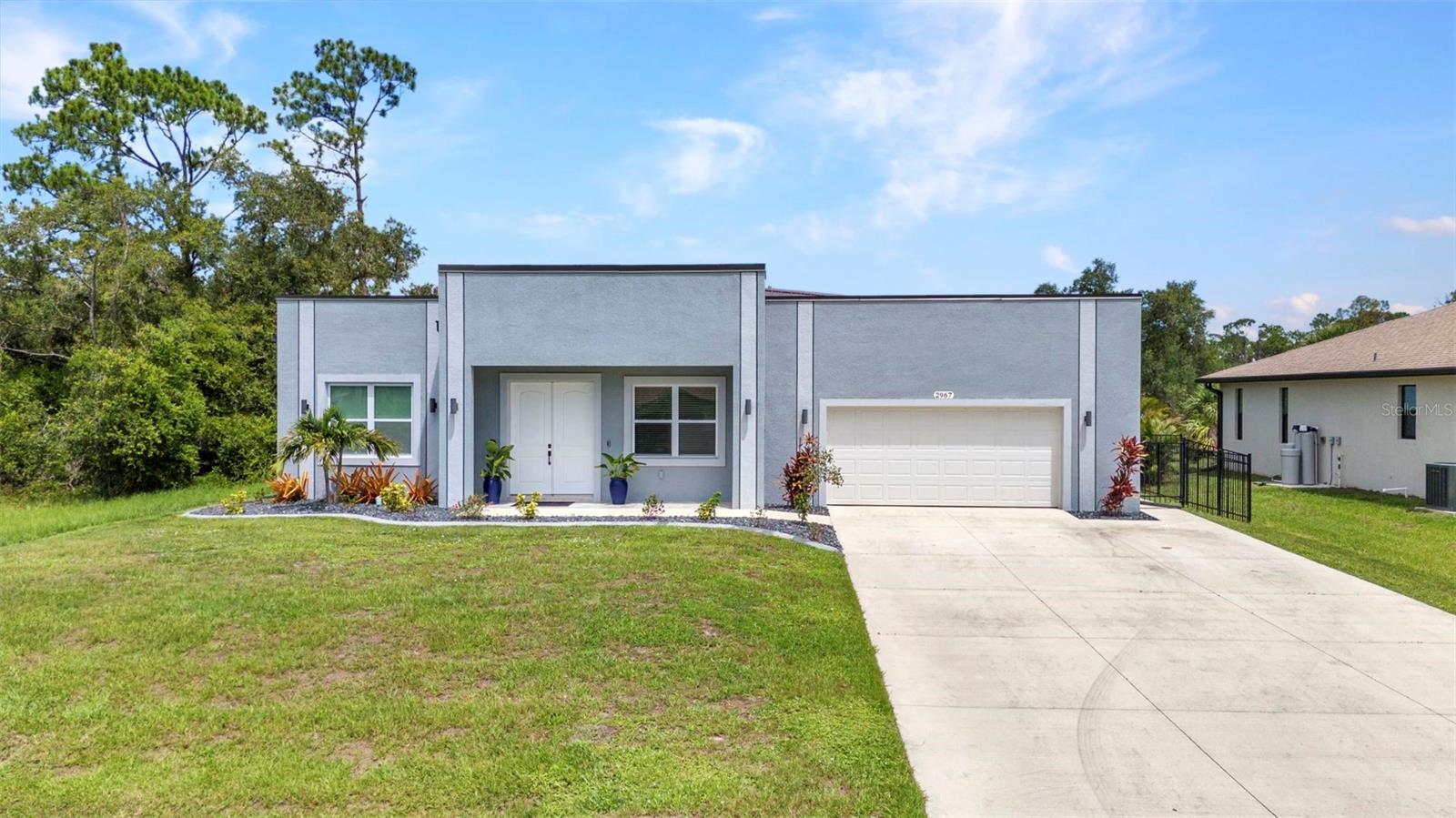 Stunning 2023 built modern 3 Bedrooms, 2 1/2 Baths, WATERFRONT masterpiece offers a rare blend of style, strength, sophistication and hurricane-resistant construction. Built with solid concrete block walls and a sleek metal roof designed without overhangs for optimal wind protection, this home is fully equipped with impact-rated windows, exterior and sliding doors, and a reinforced impact garage door. Inside, you'll find soaring 10-foot ceilings, 8-foot doors throughout, sleek ceramic tile floors, and tile-to-ceiling bathrooms. The expansive chef’s kitchen features an oversized quartz island, pantry, and stainless steel appliances including a double-door refrigerator with water and ice dispenser. A spacious laundry room with an utility sink. Smart details include LED lighting, anti-fog LED mirrors, remote-controlled ceiling, and modern heavy-duty door hardware. Enjoy indoor-outdoor living with screened in patio access from the kitchen, primary suite, and third bedroom. The primary closet is reinforced and can function as a safe room. Additional highlights include an oversized 2 car garage with extended wide driveway, aluminum fencing, rain gutters, and beautiful views of a fresh water canal. This unique home is packed with thoughtful features and high-end finishes—come see the details in person before it’s gone!
