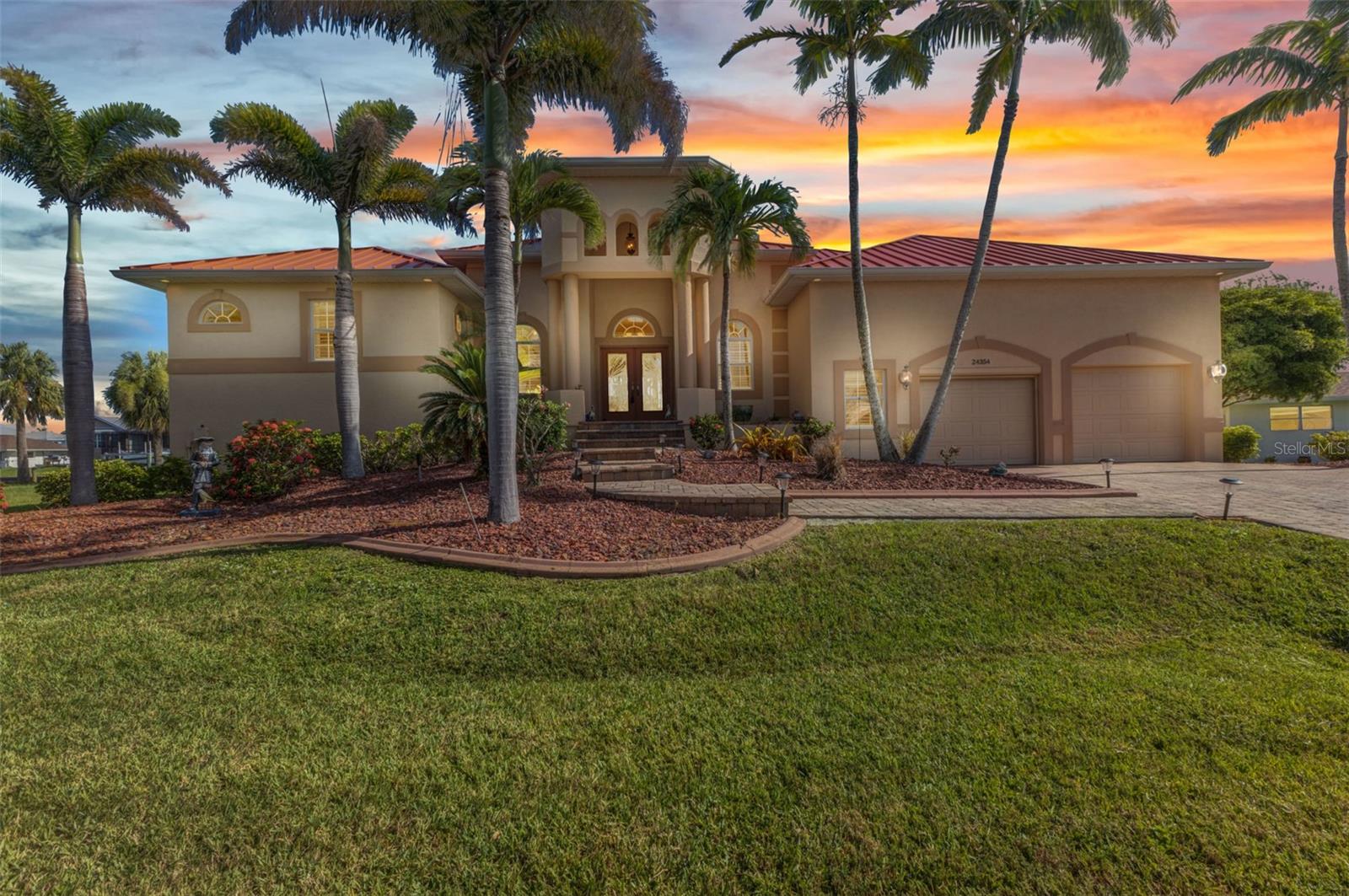Welcome to 24354 Pirate Harbor Blvd, a beautifully maintained custom home in the desirable waterfront community of Pirate Harbor. Ideally positioned at an elevation of 11.5 feet, this home not only provides peace of mind but also offers stunning water views and direct sailboat access to Charlotte Harbor and the Gulf of America—making it a perfect retreat for boaters and sunset lovers alike. Built in 2009 and lovingly cared for by its original owners, this home offers over 2,400 square feet of thoughtfully designed living space. From the moment you enter through the elegant double front doors with etched glass, you're greeted by an open and airy layout featuring diagonally laid tile, tray ceilings, and abundant natural light. The spacious living room flows seamlessly into the kitchen and dining areas, creating a warm and inviting atmosphere. Just off the main living space, an office or den with double doors and a tray ceiling offers a quiet place to work, create, or unwind. A highlight of the dining space is the stunning aquarium window, offering peaceful views of the water and lanai—an ever-changing natural backdrop that brings the outdoors in. The kitchen is both functional and charming, featuring a center pot sink, a raised dishwasher for added convenience, a breakfast bar for casual dining or entertaining, and lighting above all the cabinetry. A subtle but thoughtful detail includes drawer handles that were carefully selected to match the countertops—one of many signs of the care that went into every aspect of this home. The primary suite is a peaceful retreat with bullnose corners, a large walk-in closet, and a pocket sliding door leading to the ensuite bath. The luxurious primary bathroom features a lighted tray ceiling, jetted tub, Roman shower, dual sinks, a private toilet area, and a linen closet. Guests will enjoy their own private wing of the home, with two bedrooms connected by a Jack and Jill bathroom featuring its own Roman shower, tray ceiling, and linen closet. There is also a conveniently located half bath with direct access to the lanai—perfect for pool days and outdoor entertaining. Step outside to a southern-exposure lanai designed for year-round enjoyment. The heated saltwater pool includes a solar cover and is surrounded by plenty of room for lounging and dining. A utility sink and pool closet with a drain—easily convertible into an outdoor shower—add to the home's functionality. The wood dock measures 8x32 and includes both water and electric at the fish station, making it ideal for cleaning your catch or enjoying an evening by the water. The 10,000 lb boat lift features a newer canvas cover, and the dock’s chairs and fishing box will stay with the home, ready for your next adventure. Inside the garage, you'll find a lofted storage area measuring 8x10 with enough height to comfortably stand—a rare and practical feature. Additional thoughtful touches include impact glass throughout, Kevlar protection for the sliding doors, pre-wired security for windows and doors, seven hose bibs for convenience, and electric outlets on every plant shelf—perfect for lighting or seasonal décor. A transferable flood insurance policy adds even more value and peace of mind. New Metal roof in 2023, HWH 2024, Water Softener 2024, AC 2020. This is a rare opportunity to own a truly exceptional waterfront property in Pirate Harbor. Schedule your private showing today and experience coastal Florida living at its finest.