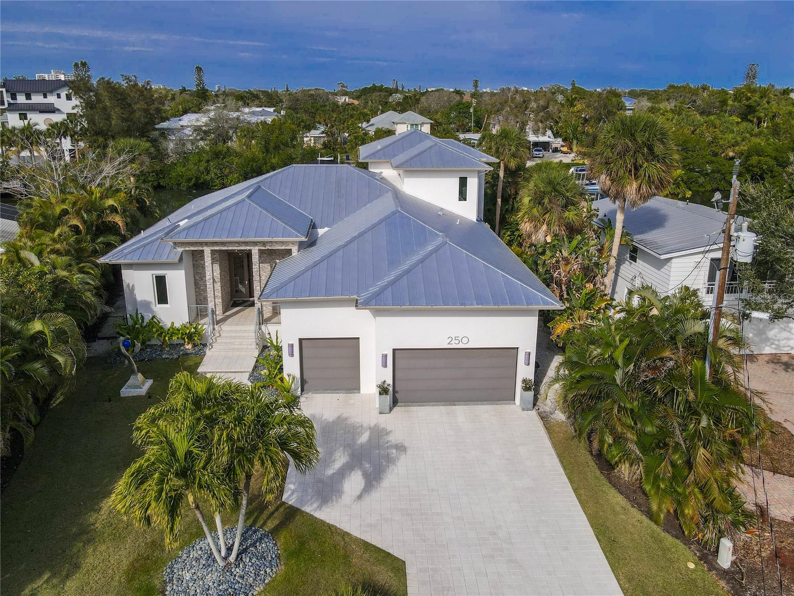 Welcome to 250 Island Circle, a coastal sanctuary nestled on the distinctive, highly desirable, coastal neighborhood of Palm Island.
THIS IS THE ONE! Come experience this wonderful, family home that embodies everything Island Life has to offer. This meticulously maintained, canal-front home offers four private en-suite bedrooms. The exquisite owner’s suite offers high ceilings, two walk-in closets, spacious bathroom, and a sitting area that overlooks the pool and Canal.
An open concept floor plan takes advantage of the 10 foot ceilings in the great room and gourmet kitchen, creating the perfect space for entertaining. The well-equipped kitchen features two ovens; one being gas as well as a six burner gas cooktop. An oversized, natural stone island, high-end appliances, and custom cabinetry makes entertaining a breeze. Bring the outdoors in with the stunning, floor to ceiling sliding glass pocket doors that flood the home with natural sunlight and create an indoor/outdoor oasis. Enjoy the epitome of Florida Living. Custom, Hunter Douglas window treatments throughout. STORAGE GALORE within the home, garage, and outdoors.
The first floor of the home includes an office/den, primary suite, two additional en-suite bedrooms, large laundry room, half bath & a bonus room that opens up to the pool area. The second floor provides a private guest suite with comfy family room plus breathtaking views of the pool and Canal from your private balcony.
Outside you’ll find a large, saltwater pool with lighting & water features for relaxing, floating, & exercise. View playful manatees, jumping fish, and colorful sea birds from your private backyard oasis. All of this is surrounded by lush tropical landscaping to maximize privacy, while not detracting from any views of the Grand Canal. Outdoor, landscape lighting creates a park like setting at night. THIS IS A RARE CANAL LOT!! Looking across this extra wide section of the canal you see only vegetation giving you privacy.
A private 40 ft. dock and 16,000 lb. lift afford you the opportunity to jump on your boat and cruise out to the bay, kayak or paddle board around the canals, or jump on your jet skis for water fun!
The oversized, 3 car garage provides ample storage for all of your beach and water toys. Potential space for three lifts for your car collection. All of this, and only a short stroll or bike ride to white quartz sands of the world famous Siesta Key Beach, makes this an opportunity not to be missed.
Enjoy an early morning walk or bike ride on the beach, take a quiet kayak ride or paddle board in the canals or on the beach, watch the beautiful sunsets by the pool and experience the fun of the Iconic, Siesta Key Village. This property reflects that magical Siesta Key Lifestyle.
YOUR DREAM HOME AWAITS!