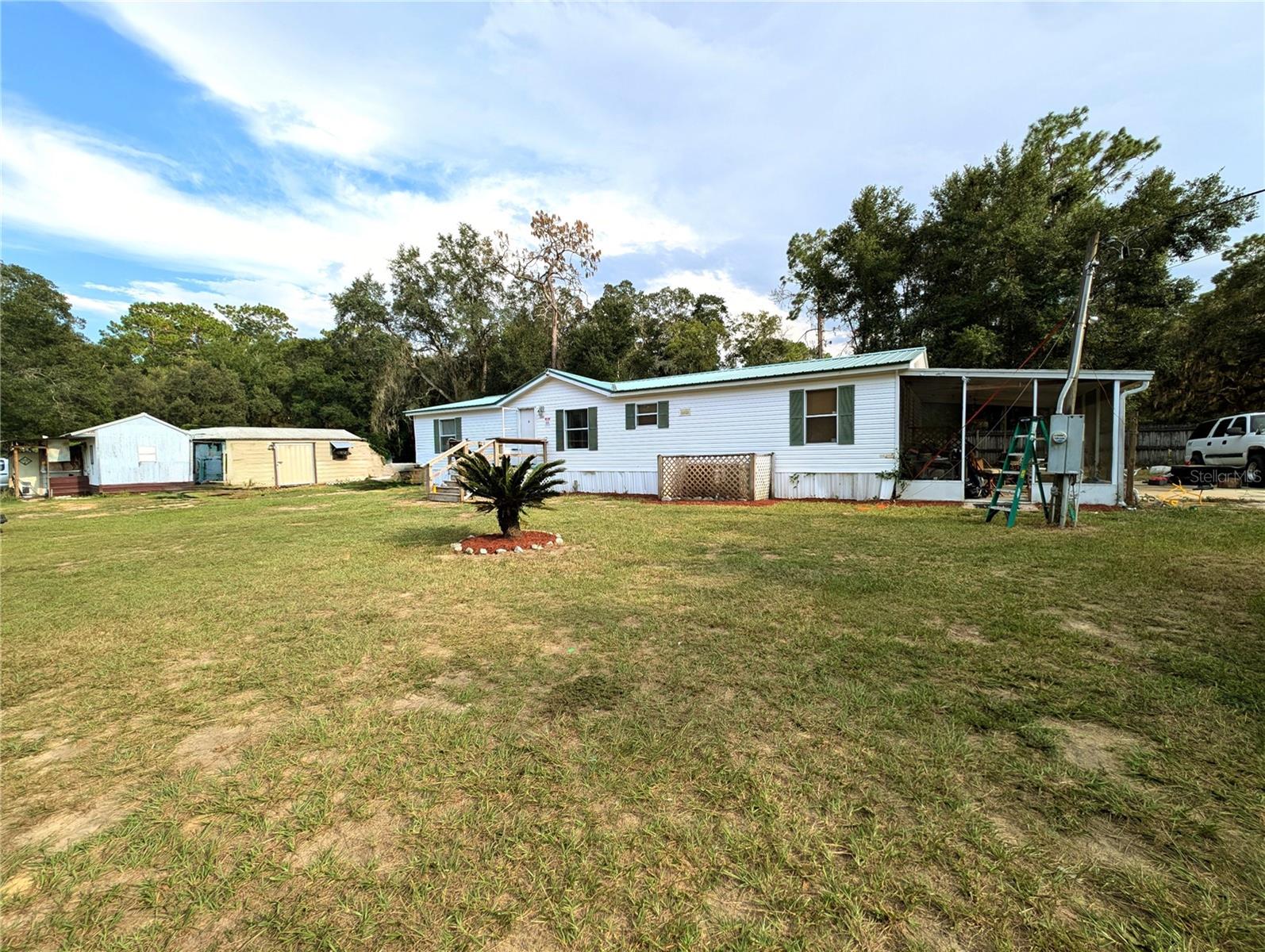 FOURTH BEDROOM OPTION! This well-appointed home is located on nearly a half acre and is nestled in an outdoor enthusiast's dream location! Go Kayaking, fishing, or snorkeling in some of the most pristine waters Florida has to offer. Just a few minutes from the crystal clear springs of Silver Glenn State Park, Lake Kerr, and Lake George, this 3/2 home also boasts an additional office which can easily be used as a 4th Bedroom by simply adding an armoire or closet. With fresh paint throughout the home, a new water heater, new custom primary bathroom shower, some new kitchen cabinets, hard flooring in every room, and a metal roof, this home is easy to maintain. This property has a huge 27.x12' screened-in porch and THREE storage sheds. One large shed has been converted to a small cabin with electricity and AC. This home also has an FHA compliant anchor system.