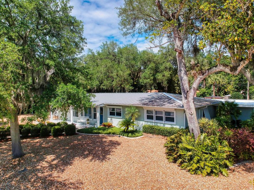 Welcome home to 1423 Live Oak.  This charming 3 bed 2 bath home is conveniently located just blocks to the fisherman friendly waters of the Indian River and a quick ride to enjoy the shopping, dining, and entertainment of historic downtown Canal Street in New Smyrna Beach. Situated on nearly 1/2 acre, this corner lot property is canopied by native oak trees, fragrant magnolias and is large enough for you to create your dream oasis with a pool or garden around its custom 2-tiered Chicago brick patio boasting over 1800 square foot and ideal for entertaining or just relaxing.  Inside, this home boasts a desirable open floor plan.  Its large family room is paved with wood flooring and capped with crown molding.  The heart of this home is its kitchen.  This space features beautiful granite counter tops, custom cabinetry, custom island,  tile flooring and newer fixtures.  This home is energy efficient with its concrete block construction, natural gas, metal roof, Bahamian and electric hurricane shutters on all windows and doors and newer double pane windows.  Other outdoor features include a handy outbuilding.  The possibilities for this flex building seem endless, ranging from studio to detached office, personal gym or even a guest house/in-law suite. With a large pole barn for your rv/boat there really is a place for everyone and everything in this immaculate welcoming home. ;Water: City