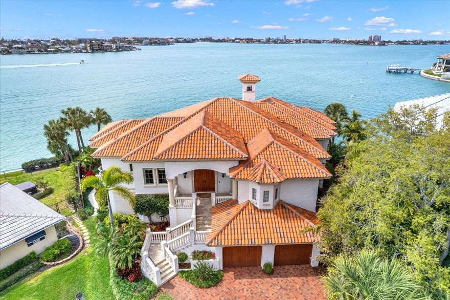 WELCOME TO THIS WATERFRONT MASTERPIECE IN THE PRESTIGIOUS OAKHURST SHORES NEIGHBORHOOD OF SEMINOLE! SITUATED ON A SPECTACULAR POINT LOT WITH 136 FEET OF BREATHTAKING DEEP-WATER FRONTAGE, THIS CUSTOM-BUILT 2009 ESTATE WAS METICULOUSLY DESIGNED FOR THE MOST DISCERNING BUYER, OFFERING AN ELEVATED COASTAL LIFESTYLE WITH UNRIVALED LUXURY AND SOPHISTICATION. Built with solid block construction from top to bottom with almost 8,000 Sq Ft of space under the roof, step inside and enjoy the expansive open-concept living spaces, soaring coffered ceilings, and panoramic water views from nearly every room. The living area boasts a custom wet bar and a 392 BOTTLE TEMPERATURE CONTROLLED WINE ROOM adjacent to the chef’s kitchen, while a natural gas fireplace, TV, and built-in gas grill on the covered balcony create the ultimate ambiance for grilling, lounging, and taking in unforgettable sunsets over the Intracoastal Waterway. The HOME THEATER (with soundproofing) offers an unparalleled cinematic experience, while the whole-home Savant light and stereo system ensure a seamless ambiance throughout, or EASILY CONVERTED TO A 3RD BEDROOM. The primary suite is a sanctuary of elegance, featuring floor-to-ceiling water views, a PRIVATE DEN/STUDY with hand-scraped wood floors, and a spa-like en-suite bath featuring Swarovski crystal-accented wallpaper, a glass shower, and freestanding soaking tub. The guest bedroom is equally beautiful, with dreamy water views and an en-suite bath, with a luxurious steam shower! A private laundry room conveniently connects to the spacious master closet, complete with a washer and gas dryer. Take the mahogany elevator to the lower level, where you'll find over 1,000 SQ FT OF ADDITIONAL CLIMATE-CONTROLLED SPACE with travertine flooring and hurricane impact sliders opening to a large covered patio and a heated pool with a spillover hot tub. There’s also a 4-CAR GARAGE with high ceilings and workshop space, hurricane impact windows and doors throughout, a clay tile roof, central vac system with a garage outlet as well, and a HUGE LOWER LEVEL STORAGE SPACE in addition to the climate-controlled area. For boating enthusiasts, this property comes with a 20,000LB BOAT LIFT, BRAND NEW COMPOSITE DOCK, and an elevated seawall for peace of mind. New Trex fencing (2024), 2 tankless natural gas water heaters, and a newly installed water softener further enhance the home’s efficiency and convenience. Designed for effortless luxury and waterfront living, this extraordinary residence offers a rare opportunity to own one of Oakhurst Shores’ most coveted properties. Schedule your private tour today and experience the pinnacle of coastal elegance.