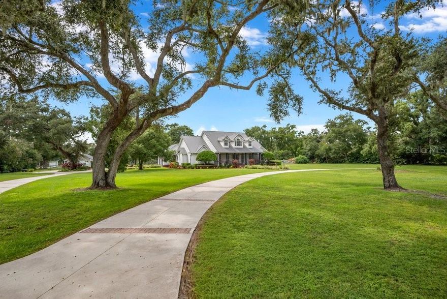 Welcome to this Majestic 5.77-acre property — the perfect blend of peace, privacy, and practicality! Located in the FISHHAWK VICINITY – YOU CAN HAVE IT ALL! —with NO HOA, NO CDD, and located in a top-rated school district! This impressive property boasts nearly *** 4,000 SqFt of living space in the beautifully updated * 5-bed, 4.5-bath main home, ***PLUS an additional 2,400 SqFt in a fully insulated and air-conditioned 40x60 metal building with 4 garage bays—perfect for a workshop, home business, storage, or guest space. Unforgettable Curb appeal stuns with grand oak trees and a circular drive, leading to a home filled with over $350K in recent upgrades, including a 2022 metal roof, 2023 well + saltwater pool system, and 2024 Generator Shed with Foundations for your Generator and Gas Tank / Generator Gas/Propane with Electric House Panel to switch to Off-Grid-Mode.  Inside, enjoy an open-concept layout with formal living and dining rooms, a cozy electric fireplace, and a chef’s dream kitchen featuring GE Café appliances, oversized island, white shaker cabinetry, a wine/coffee bar, and endless storage. The split-plan layout offers a luxurious primary suite on one side, two additional main-floor bedrooms sharing a renovated bath, and two more bedrooms with full bath upstairs—plus walk-in attic storage. Outside, relax on the massive covered/screened lanai overlooking your private saltwater pool and beyond, a fully fenced backyard. Need space for toys or tools? The detached 60 X 40 metal building includes 4 bay doors, RV hookups, a full bath, screened lanai, and A/C. Additional features: 2-car attached garage + 2-car carport (2025), smart home tech, security system, 10-zone irrigation, and pet-safe fencing. With no deed restrictions, there’s plenty of room for your RV, boat, animals, hobbies, or business gear. All of this just 30 minutes to Tampa or Lakeland, and minutes to FishHawk, Plant City, Brandon, and top-tier shopping. BRING YOUR TOYS & ANIMALS  - ATTENTION: Small Business Owners, Car Collectors, and Equestrian Enthusiasts...Dream Estate Alert! Don’t miss this rare opportunity—schedule your private tour today!