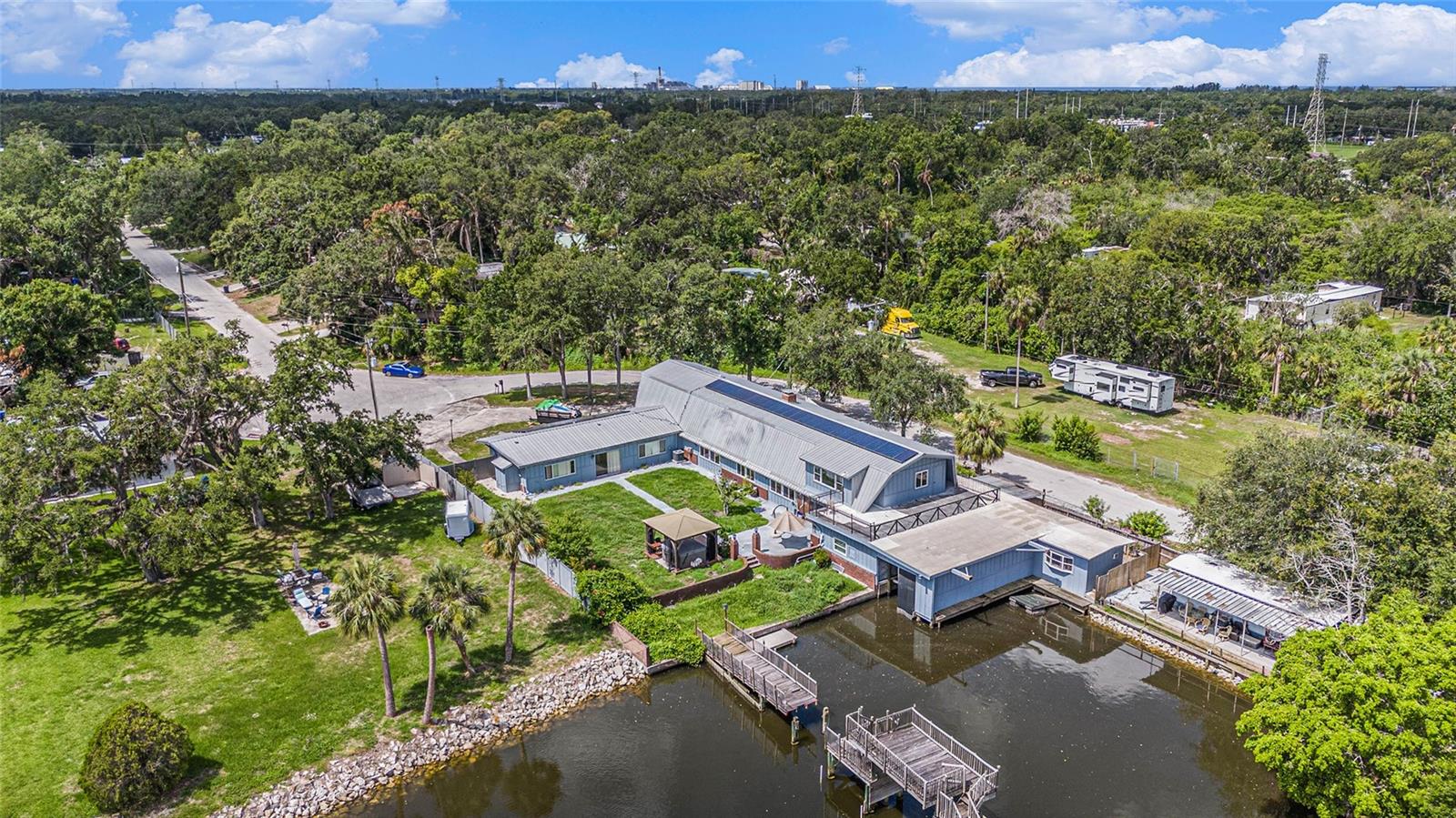 This is a rare opportunity to own a truly unique five-bedroom, four-and-a-half-bath compound nestled in the heart of Florida's waterfront paradise. The crown jewel of this property is the location, perched directly on the Alafia River with endless potential for transformation. With an investor mindset and a bit of creativity, this one-of-a-kind home can become a showstopper. The main house features soaring cathedral ceilings with exposed wood beams and a dramatic two-story fireplace that connects the kitchen and living area, creating an open, inviting space filled with natural light. A wide staircase adding both elegance and accessibility to the upper level. Two upstairs master suites, both with ensuite baths. One master opens to a private deck offering stunning water views. The lower level of the main home has been refreshed with new drywall and upgraded electrical following minimal water damage. Remediation has been fully completed, including the installation of a brand-new AC unit. The bottom floor is prepped and ready for your vision. The layout includes a detached two-bedroom guest house or mother-in-law suite with its own entrance, kitchen, 1.5 baths, and laundry, offering excellent income potential for short or long-term rental use. Additional highlights include paid-off solar panels for reduced energy costs, a newly serviced septic system, a fully fenced yard, a high-clearance RV-ready carport, and a second garage with additional laundry access. The backyard is a private retreat with a reinforced seawall, heated spa under cover, boathouse with a remote-controlled lift, and a dedicated fish-cleaning station for your catch of the day. The home is located with quick access to I-75, US-41, and the Crosstown, making it ideal for commuters or vacation renters. With no HOA or CDD restrictions, this property is perfect for use as an Airbnb, full-time residence, or even a waterfront event venue. Repairs are currently underway, and now is the time to act fast and take over the project while the opportunity is still available. This is a boater’s dream home with character, flexibility, and space to make it your own. Bring your offers and let your vision bring this waterfront compound to life.