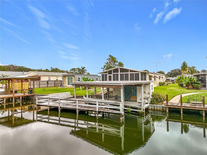 Welcome to 25933 Zinnia Lane in Astatula. This waterfront home sits on a canal with direct access to Little Lake Harris and the entire Harris Chain of Lakes. It has 3 bedrooms, 2 bathrooms, a family room, living room, screened front porch, and a large 24' x 18'8" screened back patio overlooking the water. The property includes a covered boathouse with lift and dock, perfect for fishing or getting out on the boat. Inside you’ll find a practical layout with plenty of closet space, a dedicated laundry room, and a kitchen that flows into the main living areas. This is a cash only sale. Whether you are looking for a full time residence, seasonal getaway, or an affordable waterfront property to update, this one has solid potential.