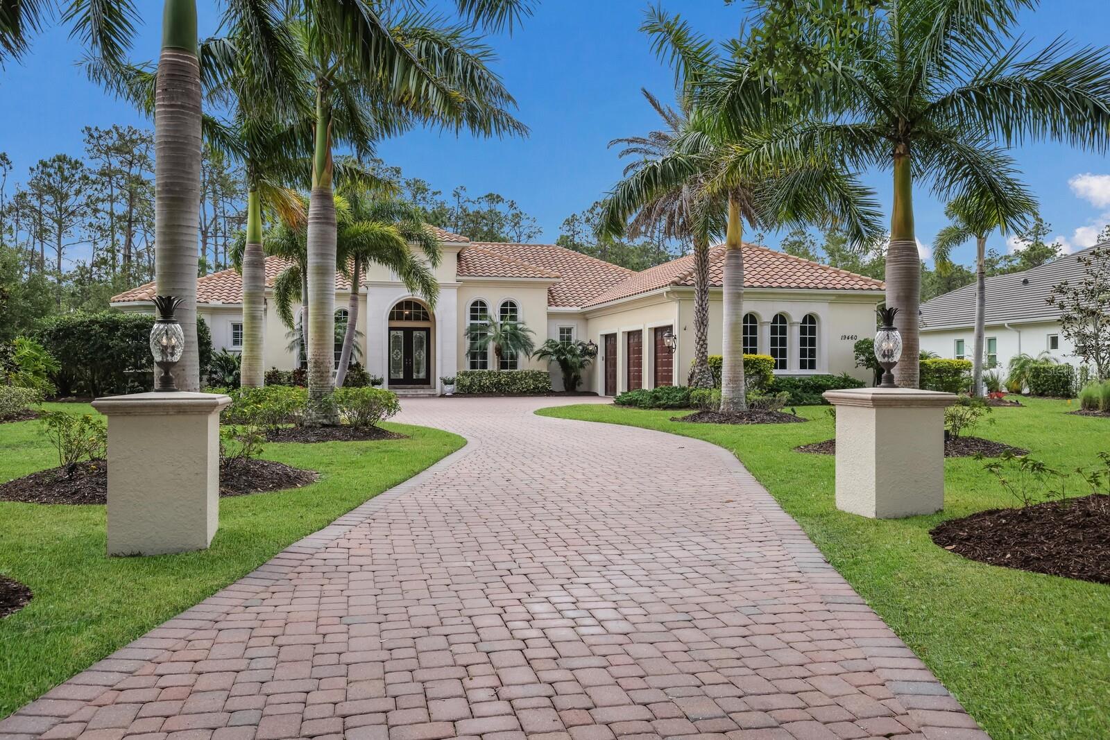 Situated on .80 acre with private preserve views, this custom designed John Cannon Home residence in the exclusive and sought-after gated community of The Concession showcases generously proportioned spaces, exceptional craftsmanship, elegant architectural details, and even a detached casita. Offering 4,476 square feet of expansive one-story living boasting a highly versatile floor plan to utilize the home in a variety of lifestyle options and limitless possibilities as a four or five bedroom residence with opportunities for an in-law suite, dual offices, guest house, and more.
Family and friends will celebrate the expansive south facing resort-styled lanai with abundant open and under cover spaces adorned with a travertine deck, retractable panoramic screens, pecky cypress ceilings, summer kitchen, gathering area with gas fire pit, a putting green, powder room, PebbleTec heated saltwater pool/spa with sun shelf, and a detached casita with full bath that affords endless opportunities to be imagined.
Seamlessly connected to the outdoors via disappearing impact glass doors is the oversized great room with double tray ceilings and dual-sided gas fireplace that opens to a club room area, also with direct access to the lanai, and is ideal for gaming, or even as a separate in-law suite as its juxtapose to a generously sized guest bedroom with ensuite full bath. Dinner guests are treated to an oversized formal dining room with volume ceilings and a climate-controlled wine room ready for 320 bottles of choice. Meanwhile chefs will delight in the beautifully appointed gourmand’s kitchen with sprawling and sumptuous leathered granite counters, Albrecht wood cabinetry with dovetail soft close drawers, SubZero and GE Monogram stainless appliances, two separate sinks, an oversized hidden pantry, and breakfast nook area all open to the great room.
Relax and unwind in the elegant owner’s retreat positioned on its own private wing, offering two oversized walk-in customized closets, volume tray ceilings, direct access to the serene outdoors, and a luxuriously appointed spa-like bath with separate vanities, stand-alone shower, and a free-standing soaking tub. Overnight visitors will be right at home in the two additional generously sized guest suites both with inviting built-in window seating with storage, centered by the home’s fourth full bath with separate vanity stations. Just off the welcoming and elegant formal living room, the residence additionally offers a designated office with double-entry doors, soaring ceilings, arched shutters, and wood flooring.
Other highlights of this 5,348 total square foot residence includes an extensive pavered circular driveway flanked by stunning royal palms, a generously proportioned laundry room, two powder rooms, tankless water heater, and attached 3-car garage with shelving and pull down attic. This custom estate is a testament to craftsmanship and a statement of refined serenity beckoning a lifestyle fulfilled in this renowned community infamous as the home to the World Golf Championship PGA golf tournament in February 2021, the upcoming World Champions Cup in December 2023, and to its striking oak hammocks, pines and large lakes, all near dining, shopping, polo, events and entertainment in the vibrant Lakewood Ranch and UTC area, and near the enriching culture and beaches of Sarasota.