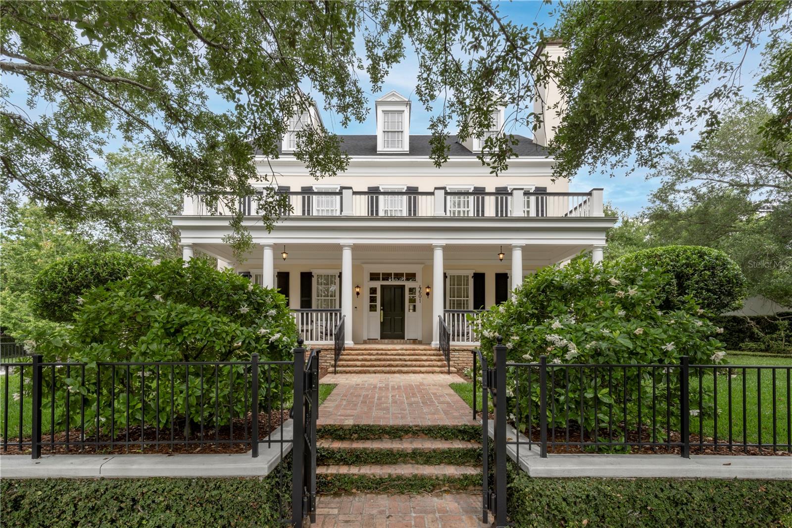 Perfectly nestled in Baldwin Park on the flagship street, this one-owner stately Georgian-style home exudes elegance inside and out. This is truly a wonderful classic and stately home that was custom built by Derek Builders, in collaboration with LRK Designs, and considered to be resting on arguably the best lot in all of Baldwin Park, at the high-profile corner of New Broad and Hopper, with over 250 feet of frontage. The owner and developer had first lot selection to thoughtfully select this specific property being the developer of Baldwin Park. While the iconic New Broad Street Park is out front of the property, quiet Virginia Park is nearby out the back of the property. A charming brick pathway leads to the front entry, enhanced by a stunning portico that lines the façade while comfortably and artfully designed on this oversized lot. Inside awaits a warm and welcoming interior, delicately adorned with hardwood flooring and crown molding throughout. This entire property is designed with incredible indoor and outdoor amenities to welcome your recreational and entertainment pursuits. The backyard invites you to a tranquil retreat, complete with an outdoor kitchen and an enchanting pool with fountain, enveloped by gorgeous greenery and lush landscape. There is a new roof and exterior paint in 2022. Although extremely well maintained, all interior finishes to include flooring, lighting, hardware, kitchen & all baths are original 2003 construction age. There is ample on-street parking to augment the oversized three-car garage. With proximity to all the eclectic dining, shopping and entertainment Baldwin Park and adjacent downtown Orlando and Winter Park areas have to offer...
