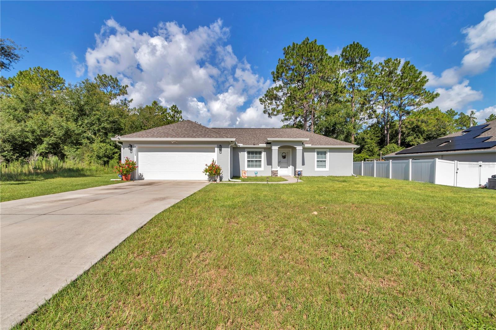 2022 CONCRETE BLOCK STUCCO WITH STONE ACCENT HOME WITH NO HOA! THIS QUAINT HOME FEATURES STORM GLASS DOOR ENTRY TO OPEN FLOOR PLAN WITH VAULTED CEILINGS IN THE LIVING ROOM OVERLOOKING SPACIOUS KITCHEN WITH STAINLESS STEEL APPLIANCES AND HIGH TOP BAR ROOM FOR 4 STOOLS WITH PENDANT LIGHTING. PRIMARY BEROOM JUST OFF KITCHEN HAS WALK IN CLOSET AND BATH FEATURES TILE SURROUND WALK IN SHOWER AND 42 INCH DOUBLE VANITY.THIS SPLIT BEDROOM PLAN WITH 2 ADDITIONAL BEDROOMS ARE ACROSS HOME AND SHARE THE 2ND BATH WITH COMBO TUB/SHOWER WITH TILE. DINING ROOM LEADS TO DOUBLE SLIDING GLASS DOORS TO UPGRADED 10 X 18 COVERED AND SCREENED IN LANAI WITH EPOXY FLOOR. JUST STEPS FROM HERE IS THE 12 X 20 STORAGE SHED WITH LOFT FOR STORAGE, 4 FOOT RAMP FOR MOWER AND 2.5 FOOT RAMP FOR PERSON DOOR ENTRY. POWER READY. HOME HAS RAIN GUTTERS, WIRED FOR GENERATOR (JUST NEED GENERATOR). HOME HAS TILE IN KITCHEN, LAUNDRY AND BATHROOMS, ALL ELSE CARPET. ATTIC STORAGE AND WHOLE WINDOW SCREENS IN ATTIC. 2 CAR GARAGE. WELL HAS FILTER ON IT AND ITS ON SEPTIC. ROOF, HVAC AND HOT WATER HEATER ALL 2022. CAMERS WILL STAY. ALL CLOSE TO WALMART AND JUST OFF 200. NEAR RAINBOW SPRINGS RIVER!