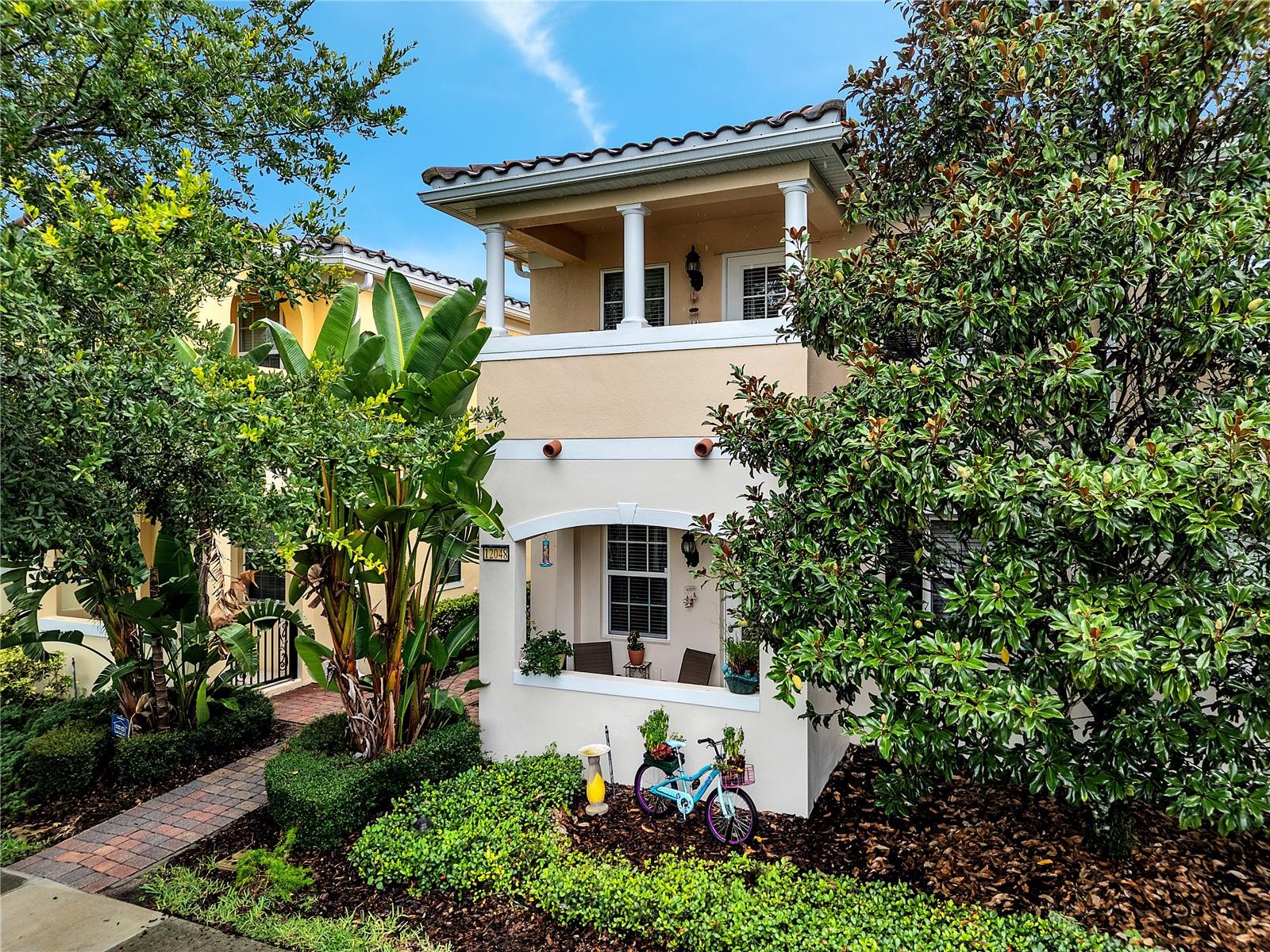 Situated in the desirable community of VillageWalk at Lake Nona, this Cayman II model townhome by DiVosta Homes is ready for its new owners. As you enter, you'll be greeted by elegant tile flooring, crown molding throughout, and timeless plantation shutters that add charm and sophistication to the first floor. The spacious living room features a striking stone accent wall and flows seamlessly into the gourmet kitchen, which boasts granite countertops, stainless steel appliances, and ample cabinetry, perfect for both everyday living and entertaining. A guest bedroom on the first floor is highlighted by rich bamboo flooring and offers private access to a covered patio, along with a convenient full guest bathroom. Sliding glass doors in the living area open to a generously sized paver patio, ideal for outdoor gatherings and connecting you to a detached double-car garage. Upstairs, the stone feature wall continues along the staircase, enhanced by bamboo steps and decorative iron railing. The second floor includes a newly carpeted primary suite, featuring a private balcony for morning coffee or evening relaxation, and a secondary primary suite offers a dedicated sitting area and private bathroom, and walk-in closet. The updated laundry room is thoughtfully designed with a custom folding counter, built-in cabinetry for extra storage, and a hanging rod for delicates. This home offers both comfort and functionality, with carefully selected finishes and upgrades throughout.
VillageWalk at Lake Nona is a thoughtfully planned master community that provides the ultimate resort-style living. HOA fees cover lawn care, high-speed internet, and cable, ensuring a hassle-free lifestyle. Picturesque bridges and scenic canals wind through the neighborhood, connecting residents to a variety of on-site amenities, including a deli, a gas station, and a vibrant town center. Outdoor enthusiasts will appreciate the lighted walking and biking trails, sports courts, and heated swimming pools, while the 24-hour fitness center promotes an active lifestyle. Just minutes away is Lake Nona Town Center, a dynamic 100-acre open-air destination featuring public art displays, upscale shopping, luxurious hotels like the iconic Lake Nona Wave Hotel, and Boxi Park—an engaging, family- and dog-friendly venue with a mix of restaurants and bars, beach volleyball courts, and a live entertainment stage. Families will benefit from access to top-rated schools, and the community's prime location near Medical City and Orlando International Airport ensures easy travel. World-famous attractions such as Disney, SeaWorld, and Universal Studios are just a short drive away.