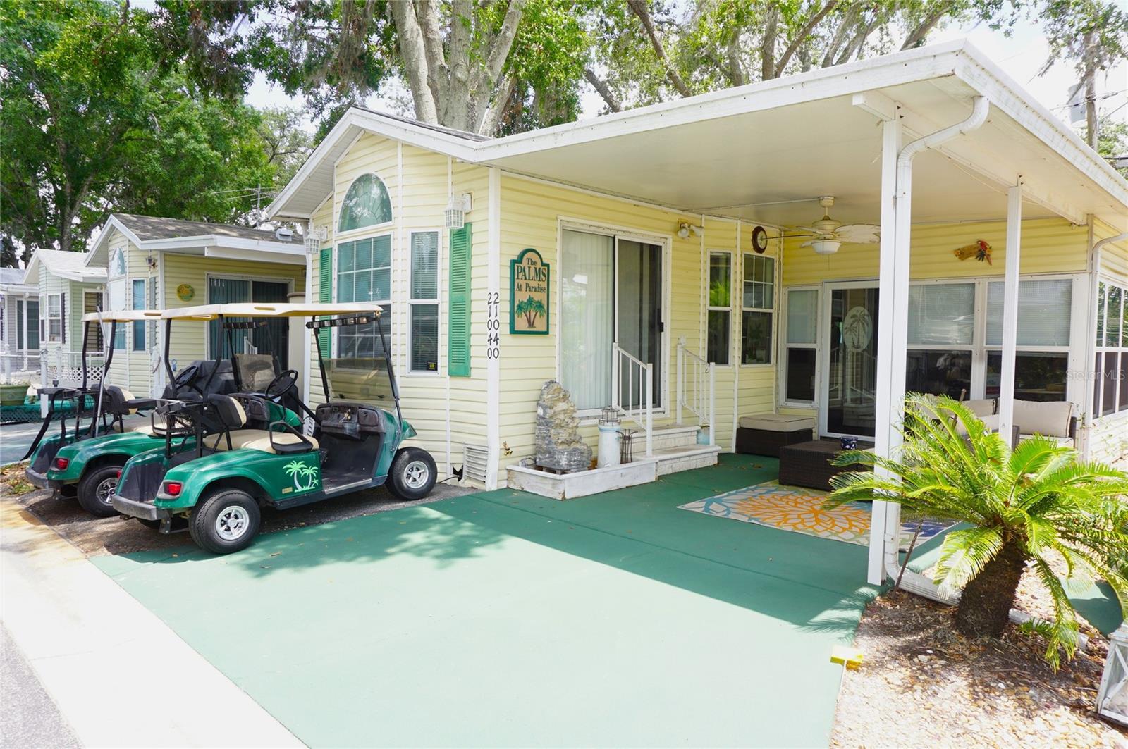 Coveted corner lot single level home located in the gated nudist/clothing-optional community of Paradise Lakes. This lovely home has a contemporary look with upscale furnishings and decor, wood laminate flooring, and neutral colors throughout. The kitchen features solid surface counters, 4-burner range, built-in microwave, dishwasher, breakfast bar, and dining nook. Spacious living room with vaulted ceilings, fan, and sliding glass doors to the outside covered patio. Full bath has tub-shower combination and large vanity with solid surface counter. The bedroom offers built-in drawers and closets with sliding mirror doors. Vaulted ceilings, crown molding, and lots of windows give this home a light and airy feel. Spread out and entertain in the heated/cooled enclosed flex/bonus room with storage closet. This property has a covered front patio, outdoor shower with glass block wall, resin storage shed, off-street parking, and two additional golf cart parking pads. New hot water heater recently installed. Two golf carts included. Buyer is responsible for verifying all information, details and dimensions. One-year home warranty included! Association approval of Buyer is required including application, fee, background check, orientation, and membership in a recognized nudist organization. Optional membership to Paradise Lakes Resort is not included in the monthly condo association fee