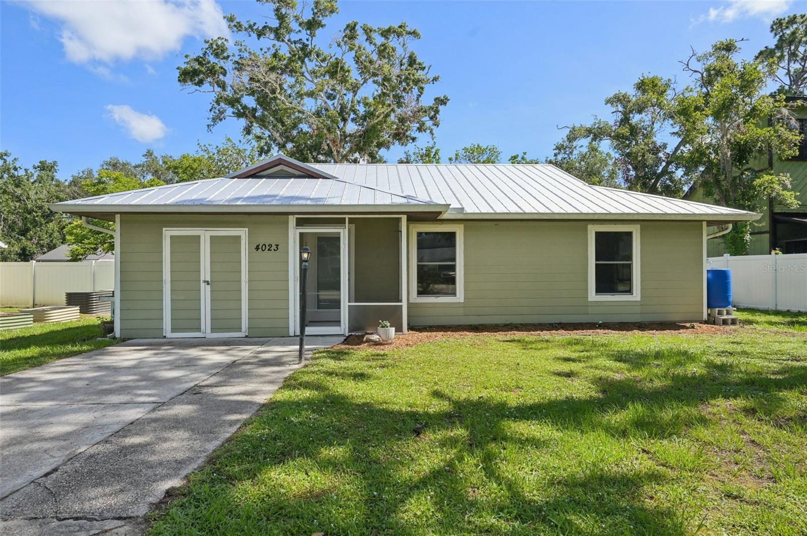 Welcome to your charming retreat in Sarasota Lakes! This cozy home is nestled among beautiful trees and boasts a large Living Room with vaulted ceilings, giving it a bright and airy feel. A great size kitchen with views of the backyard. The spacious primary bedroom features a newly remodeled, elegant bathroom. The garage has been partially converted, providing a perfect space for a 3rd bedroom, studio, playroom, or den, while still having room for storage. Enjoy your mornings or evenings on the large screened patio, perfect for lounging or entertaining, and enjoy the privacy of the wooden deck and spacious backyard with a handy shed. All the windows and French doors are hurricane impact, giving you peace of mind. The metal roof, replaced in 2022, is another great feature for worry-free living. This lovely home is just waiting for you to add your personal touch and make it your own!