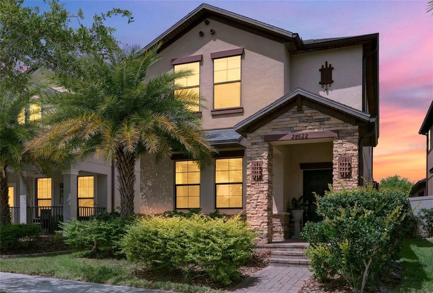 Located in the desirable Arbors at Wiregrass Ranch in Wesley Chapel, this single-family 4-bedroom, 3-bathroom two-story home, built in 2016, offers 2,023 square feet of living space and a versatile floor plan. A unique rear-entry 2-car garage enhances both functionality and curb appeal, with access from the back of the home leading through a covered patio into a private rear entry—creating a practical and less common layout. The beautifully designed exterior showcases standout curb appeal with a stone-accented façade, charming covered front porch, and elegant column detailing that create a lasting first impression. A brick paver walkway leads to the inviting entry, framed by lush landscaping and a mature palm that enhances the home’s Florida appeal. The main level features a welcoming foyer that opens to the living and dining areas and flows seamlessly into the kitchen. A first-floor bedroom and full bath provide flexibility for guests, multi-generational living, or a home office. The kitchen offers a functional and well-appointed layout, highlighted by a spacious granite island with bar seating and an undermount double sink. Rich wood cabinetry topped with crown molding provides abundant storage, complemented by ample counter space and a full suite of stainless appliances, including a built-in microwave, smooth-top range, dishwasher, and refrigerator. Pendant lighting above the island and recessed lighting enhance the bright, open feel, while the layout flows seamlessly into the dining and living areas—ideal for everyday living and entertaining. Upstairs, the primary suite is thoughtfully set apart from the additional two bedrooms, offering added privacy, and features an ensuite bath with a soaking tub surrounded by tile and a tiled shower. The second floor also includes a full bathroom and a conveniently located laundry room. The home will require some interior updates, including repainting and replacing upstairs carpet. Ideally suited for buyers looking to renovate and customize or for investors seeking a value-add opportunity.  Situated in the heart of Wiregrass Ranch, this well-established master-planned community is just minutes from top-rated schools, premier shopping, dining, and entertainment. Enjoy close proximity to The Shops at Wiregrass, Tampa Premium Outlets, AdventHealth Center Ice, as well as nearby parks, walking trails, and community amenities. Low HOA fees add to the home’s overall appeal. Don’t miss this opportunity to add your personal touch and create value in one of Wesley Chapel’s most sought-after communities—schedule your private showing today.