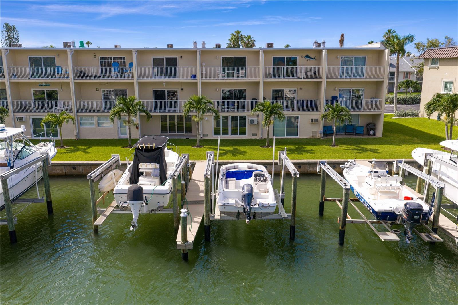 EVERY DAY will feel like a vacation in this BEAUTIFUL waterfront townhome with DEEP WATER PRIVATE DOCK, LIFT, and INSTANT ACCESS to the Gulf. Your sunset and dolphin cruises, fishing, and Eleanor Island SANDBAR ESCAPES start in your backyard - no public launches! Welcome home to manicured lawns and BEAUTIFUL ENTRIES. You will love the stylish OPEN LIVING SPACE on the main floor that boasts rich engineered WOOD FLOORS, a timeless kitchen and island with EXTRA DEEP CABINETS, pull-outs, custom glass, BUILT IN DESK, stainless appliances and thoughtful LIGHTING OPTIONS. Main Floor Designer touches include a convenient POWDER BATH, chandelier cove in the Dining Area, a stone surround FIREPLACE in the Living Area and IMPACT SLIDERS opening to a WATER VIEW BALCONY. The next level holds the PRIMARY BEDROOM with an updated EN SUITE BATH, large closet and PRIVATE BALCONY facing the water. An inviting guest room features an ample closet and a guest bath with an extra wide soaking tub. Between the two bedrooms is FLEX SPACE with laundry, closet, and room for a home office or hobby area. The ground level offers an OVERSIZED one car garage and a Bonus Room with DIRECT ACCESS TO YOUR BOAT. The garage did have water intrusion during Helene but has been PROFESSIONALLY remediated, water-proofed, and UPGRADED with epoxy floors, flow-through vents, and mini-split AC. UNEXPECTED EXTRAS are FEMA PAID Flood Insurance (3 years); PET FRIENDLY COMMUNITY; Annual rentals permitted; Close to Capri Isle Park, Restaurants, Shops and TREASURE ISLAND BEACHES. So many beautiful features you will want to MAKE THIS YOUR HOME TODAY!
