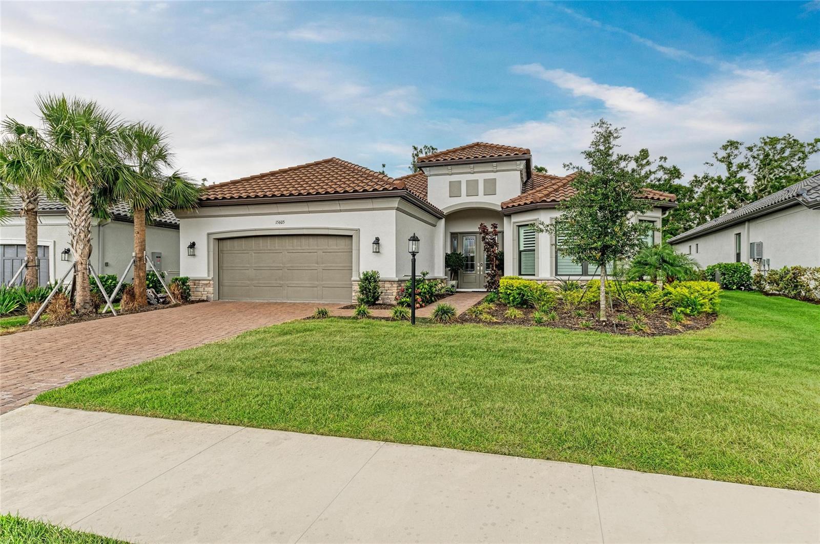 Welcome to Elevated Florida Living in Esplanade – Azario at Lakewood Ranch!
Experience the perfect blend of elegance, comfort, and privacy in this meticulously crafted 2023-built home offering 3 bedrooms, 3 bathrooms, a dedicated den/office, and a rare tandem 3-car garage—all thoughtfully designed with timeless upgrades and modern conveniences.
From the moment you enter, you'll be captivated by the refined ambiance created by engineered wood flooring throughout (with plush carpeting in Suites 2 and 3), soaring tray ceilings adorned with crown molding, and custom upgraded lighting that complements every space.
Each of the three spacious bedrooms features its own ensuite bath, offering privacy and comfort for family and guests alike. Bay windows in two bedrooms flood the rooms with natural light and add architectural charm. The home’s expansive interior showcases 8’ solid-core doors, B&G interior shutters, and soft-close cabinetry with upgraded shelving.
The gourmet kitchen is a culinary dream, boasting quartz countertops, stainless steel appliances, a smart faucet, and a large kitchen island with an additional prep sink. The natural gas range is complemented by an upgraded vent hood, while designer plumbing fixtures elevate the entire space. The casual dining extension flows effortlessly into the great room—enhanced by a high-quality speaker system that continues into the office and rear lanai, perfect for entertaining or relaxing in style.
Step outside to your serene, screened-in lanai with a built-in summer kitchen, ideal for alfresco dining or hosting guests against a backdrop of Florida’s natural beauty. The home backs up to a heavily wooded preserve, offering rare and sought-after privacy. Silent ceiling fans are thoughtfully placed throughout all living areas, including the lanai, to ensure year-round comfort. The garage features an acrylic-sealed floor and an enlarged tandem space to accommodate extra storage or your favorite hobby.
Living in Esplanade – Azario means access to an unparalleled lifestyle, including:
A private, championship 18-hole golf course
Onsite golf pro shop
Gated community for added security
Elegant clubhouse and breakfast bar
Resort-style pool, spa, and poolside Bahama Bar
Culinary Center with signature dining experiences
State-of-the-art fitness and wellness facilities, including a full-service spa and hair salon
Tennis and pickleball courts, dog park, and scenic walking/biking trails
Full-time Lifestyle & Activity Manager to curate events and social connections
Whether you're enjoying a peaceful morning in your lanai or an afternoon on the golf course, this home is the epitome of luxury living in one of Lakewood Ranch’s most sought-after communities.
Don’t miss the opportunity to make this move-in-ready, designer-detailed home yours—schedule your private tour today!