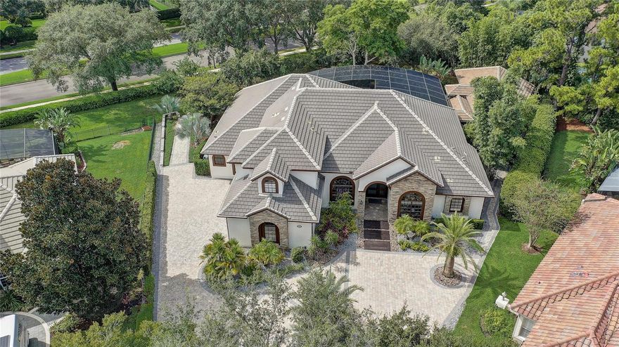 Welcome to your dream home in Heathrow! Nestled on Langham Terrace in the prestigious guard-gated community of Heathrow, this custom estate offers luxury living. Heathrow is celebrated for upscale homes, lush natural surroundings, and access to golf, country club facilities, parks, shopping and highly rated schools—all within minutes from Orlando.
Inside the home you’ll find a versatile floor plan with 4 bedrooms and 4.5 baths. The primary suite features a spa-like en suite with a separate shower and soaking tub. Two bedrooms share a Jack & Jill bath. A main-floor in-law suite includes a zero-entry shower and a private door to the screened patio. A multipurpose loft/bonus room upstairs has its own full bath and inside balcony—ideal for guests, a home theatre or office. Formal living and dining rooms anchor the entry and showcase elegant entertaining spaces. The open modern kitchen boasts custom-built cabinetry and stone countertops, providing abundant storage, and the high-end Miele appliance package includes a cooktop, oven, dishwasher and built-in refrigerator. A breakfast nook and large den/family room with built-ins form the heart of the home. This gourmet space flows seamlessly to the pool area. A convenient half bath on the main level for guests and under-stairs storage and thoughtful nooks maximize organization. A laundry room and extra closets offer more storage.
Outdoor living begins with the redesigned screened pool and patio featuring an electronic louvered pergola that lets you control sunlight with the touch of a button. The complete outdoor kitchen (grill, prep area and sink) is perfect for entertaining. A 1,555?sq?ft air-conditioned accessory building with full bath serves as a gym, guest house, studio, workshop or party space; two mini-split AC units keep it comfortable year-round—ideal for gatherings or yoga. A mosquito-repellent system and built-in audio speakers extend comfort and entertainment outdoors, and professionally landscaped grounds with lush tropical plantings create a tranquil oasis.
Smart upgrades include programmable lights, ceiling fans and a security system; smart controls throughout the house make day-to-day living effortless.
Heathrow residents enjoy 24-hr guard-gated security and a wide array of amenities. The community boasts a country club with championship golf and clubhouse, a racket club, athletic fields, park areas and miles of walking and jogging trails set amid preserved natural lands. Playgrounds, sports fields and top-rated schools nearby appeal to families. These features provide a serene backdrop while placing you close to popular restaurants and shopping. Nearby attractions include Colonial Town Park, the Cross Seminole Trail and downtown Lake Mary’s boutiques. With quick access to I-4 and SR-417, Heathrow remains one of Central Florida’s most sought-after communities for convenience, dining and an exceptional quality of life.
Why 1441 Langham Terrace? Luxurious custom construction with modern conveniences and a flexible floor plan. Resort-style pool area with pergola and full outdoor kitchen. Multi-use accessory building adds significant living/working space. Located in one of Central Florida’s most coveted guard-gated communities known for golf, upscale amenities and natural beauty. Schedule your private showing today and discover this unique blend of luxury, smart features and lifestyle amenities. This property is not just a house—it’s a statement of refined living in Heathrow.