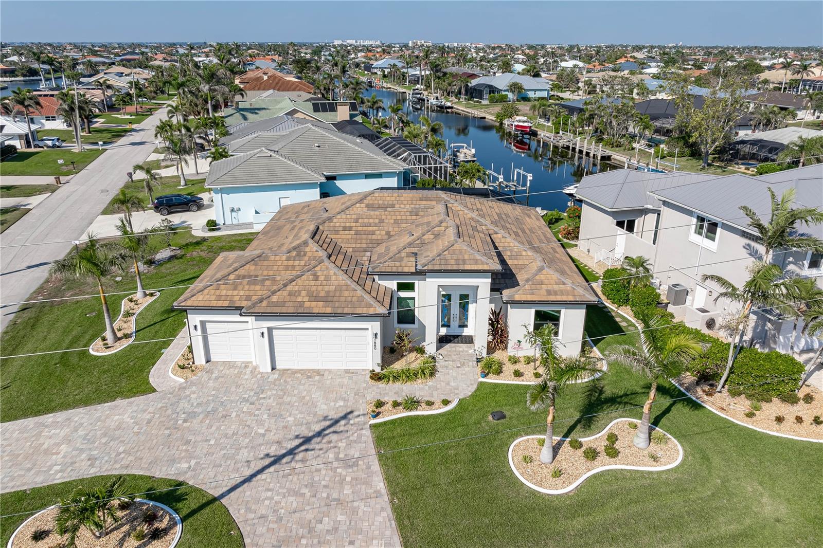 SHOWCASE HOME W/A WATER VIEW IN PGI! Check out this exceptional 3 bed/3.5 bath + den, custom waterfront home in Punta Gorda Isles built by Harbor Home Builders in 2022. Why wait for new construction when this home is MOVE-IN READY?!? ~ LUXURY & HIGH END FINISHES THROUGHOUT - NO EXPENSE SPARED DURING CONSTRUCTION ~ The property offers over 2,200 sq ft of living space w/an open-concept design, seamlessly blending indoor and outdoor living. The layout is based on a modified Siesta floor plan - with the addition of a half bath in the den. Feature wall in great room offers a built-in fireplace. It serves as the focal point of the room w/textured stone, glass shelves & lighting. A spacious den/home office is nestled just off the foyer. The half bath is tucked away here. Gourmet kitchen is a chef’s dream, featuring contemporary cabinetry w/under cabinet lighting, quartz countertops, stainless steel appliances, RO under sink filtration, a 5-BURNER GAS COOKTOP w/stainless hood plus a large center island with breakfast bar seating & pendant lighting. There's also a large, walk-in pantry so no shortage of storage here! Mitered bay window in the dining area overlooks the pool & canal view. Architectural details include tray & double tray ceilings, gorgeous marble floors, stained glass entry doors, & a large interior laundry room w/adjacent mudroom & coat area. The master suite has walk-out access to the lanai, an spa-like master bath w/dual sinks, a seated vanity area, large tiled shower & oversized walk-in closet. The split bedroom layout features generous guest rooms - each w/large walk-in closets & en-suite bathrooms. One of the guest baths doubles as a pool bath w/access to the lanai. Outside, the brick paver lanai surrounds the in-ground, propane-heated pool w/attached spa. A tanning ledge allows you to stay cool while soaking up some Florida sunshine! A patio w/stone wall surrounding it is steps from the back door. It's the perfect spot for a fire pit. Sit back & enjoy the lovely canal view out here. Additional highlights include a brick paver circular drive leading to the three-car garage, water softener, professionally landscaped yard, 500-gallon buried propane tank (for gas range & pool/spa heat), central vacuum system & whole-house hurricane protection w/impact-resistant doors & windows plus electric roll-down shutters on the lanai. No expense was spared during construction: enjoy the best of everything here - nothing to update - just move in & enjoy! Punta Gorda is a vibrant waterfront town known for its boating lifestyle, active art & music scene, and top-rated golf courses. Miles of sidewalks connect you to the rest of Punta Gorda Isles, several area parks & even historic downtown Punta Gorda. Take advantage of the active lifestyle awaiting you here: you can walk, bike or kayak to almost anywhere you'd want to go! Claim your spot in paradise & start living your Florida dream here.