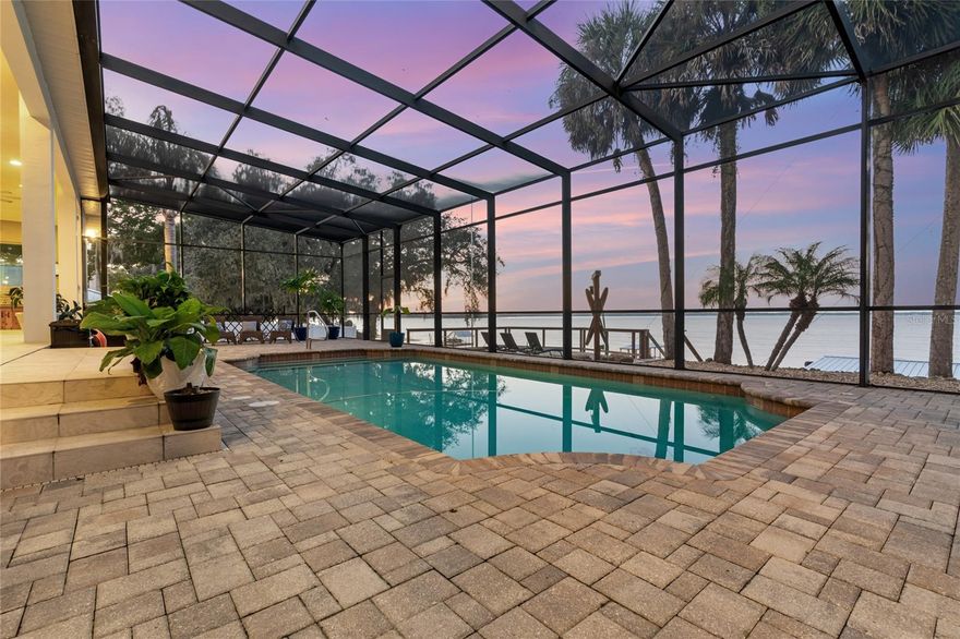 Welcome to this breathtaking custom-built 3 bedroom, 2 1/2 bathroom home ON 1.24 acres, perfectly situated on the serene shores of Lake Weir. This exceptional residence effortlessly blends comfort, elegance, and resort-style outdoor living with 108 feet of lake front access. Upon entry, you’ll be captivated by the open-concept design, highlighted by high-end finishes throughout. The expansive living area is enhanced by an open cupola that bathes the space in natural light, creating a warm and inviting atmosphere. Step outside and discover your very own private oasis. The top level of the multi-tiered deck features a spacious screened lanai, home to a sparkling pool—perfect for basking in the Florida sunshine. On the second level, you'll find an inviting sitting area, an ideal space for dining and entertaining. The private dock offers direct access to the lake to launch a boat or jet ski's, perfect for boating, fishing, and water sports. This exceptional property also includes a 3-car garage with plenty of storage for vehicles and outdoor gear, along with a dedicated shop featuring 4 roll-up doors and 27-amp power along with a generator that will power the entire home. Whether you're seeking a peaceful lakeside retreat or an entertainer’s paradise, this home truly offers the best of both worlds.