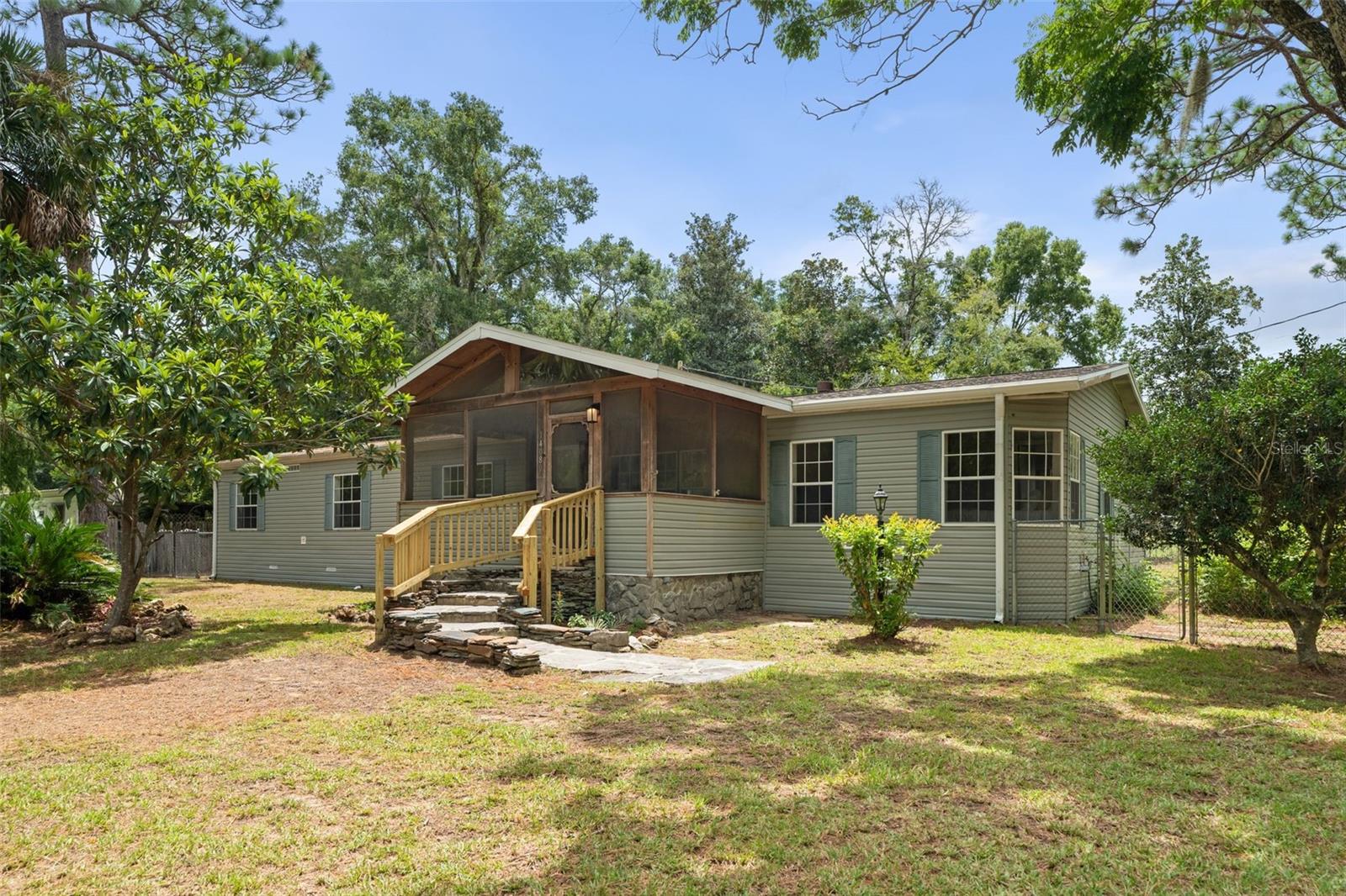 Spacious and beautifully renovated, this 2002 manufactured home offers 2,356 sq ft of living space on a peaceful .48-acre lot in a quiet Williston neighborhood—just under 30 minutes to Gainesville. Inside, enjoy a fresh, modern interior with luxury vinyl plank flooring throughout and tile in the screened porch, main closet, and laundry room. The open floor plan features a welcoming living area with fireplace, a bright kitchen and dining space with access to both a charming front screened porch and a spacious back covered porch, plus 4 generous bedrooms, 2 full baths, and a utility sink in the laundry room. Major 2025 upgrades include a brand-new asphalt roof, new HVAC system with 5-ton AC unit, and new hot water heater. Built with 2x6 exterior walls, the home also offers a fenced backyard with butterfly garden landscaping, flagstone entry walkway, storage building, and kennel building—perfect for pets or hobbies. Conveniently located near Williston’s local amenities and within easy reach of Gainesville’s job market, universities, and medical centers, as well as Cedar Key’s Gulf Coast beaches, Devil’s Den Spring, and Goethe State Forest, this move-in ready home offers the ideal blend of small-town charm and modern convenience.