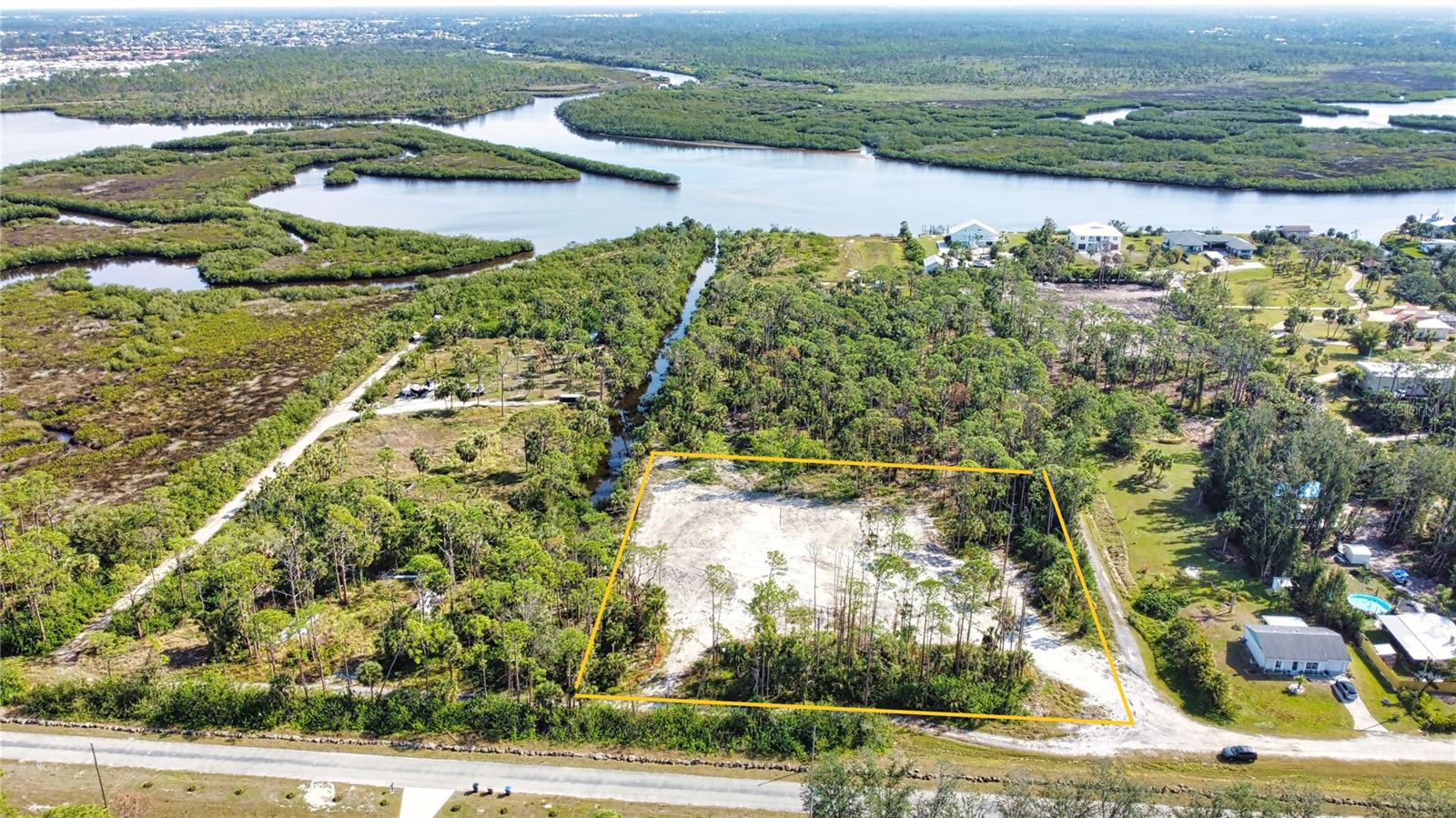 Discover a rare and exciting opportunity to design and build your dream home on this stunning 2-acre residential parcel with direct access to the Myakka River. Tucked away in a serene and private location, this property offers a harmonious blend of natural beauty and convenience. Nestled just north of the picturesque Myakka State Park, the land is bordered by pristine Florida nature, providing an idyllic setting for your future home. The property is situated at the end of a canal leading directly to the Myakka River, offering a unique lifestyle for nature lovers, boating enthusiasts, or those seeking a peaceful retreat. Despite its secluded feel, the parcel is conveniently located just east of the highly desirable Wellen Park community, ensuring access to shopping, dining, and other everyday amenities. Looking to the future, the planned extension of River Road will further enhance the location's accessibility, providing a direct connection to the newly built high school and the pristine sands of Manasota Key Beach. This property truly offers the perfect combination of tranquility, convenience, and potential. This 2-acre corner lot on a canal is zoned RE1, has an active single-family permit, and comes with a clean environmental survey—ready for immediate development. The seller has enhanced the property by bringing in over 500 truckloads of soil, which has been compacted and leveled to a 12-foot elevation, creating a buildable pad approximately 180’ x 80’. Additional improvements include installed silt fences, a newly dug freshwater well, a transformer pad, and underground electrical conduit, making this property truly ready to go. Seller has plans for a fully permitted barndominium style residence (see photos) available to purchase. Lot dimensions are approximate and should be verified by buyer. Please see additional parcels that are available - MLS # A4637409, A4637412 and A4637413.