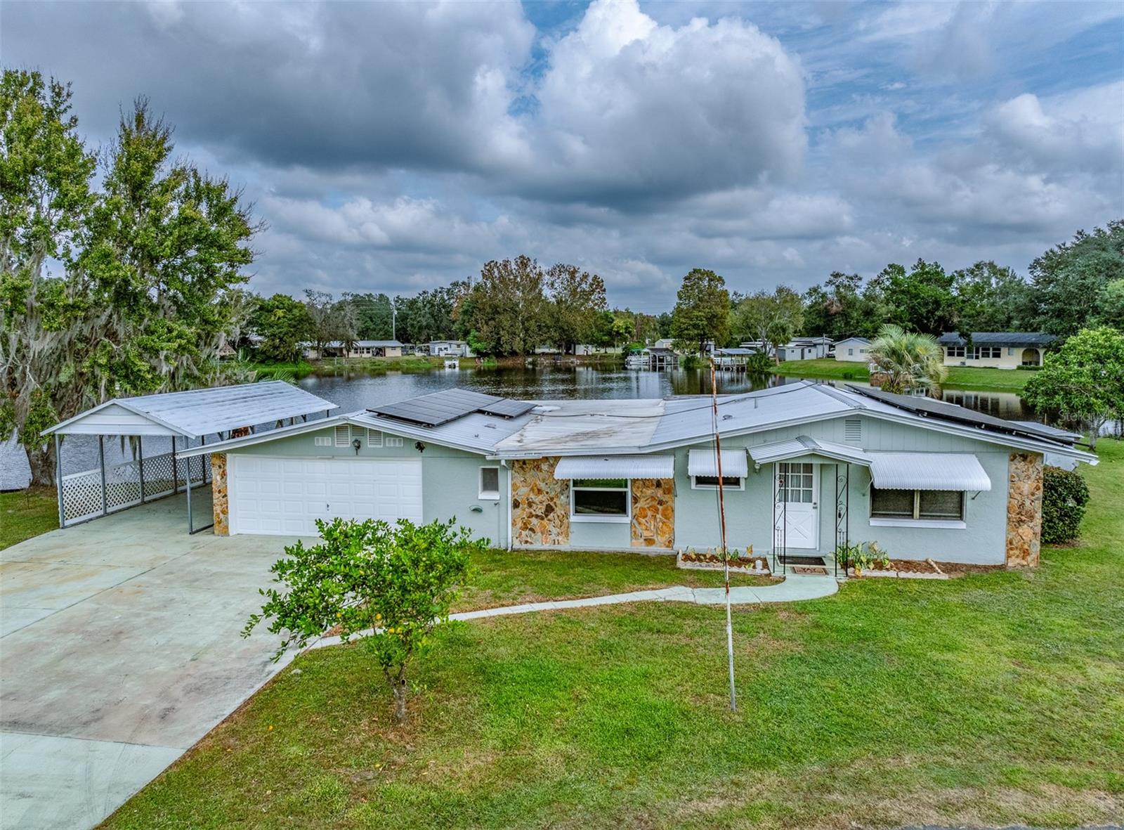 OWNER FINANCING AVAILABLE !!! CALL AGENT FOR DETAILS. This WATERFRONT is on a pond/canal that opens up to the Henderson Chain of Lakes. Because of the vast marshlands, this community stays dry in the worst Mother Nature throws at it. Here, you can enjoy great bass fishing right off the covered shady dock, or explore farther into the lake by boat. Park your boat on your own dock or under the carport/boatport, OR in the 2-car attached garage, and take advantage of the endless marshlands, canals, and lakes. Relax in your concrete block waterfront house with a wall of windows to enjoy the view and exotic birds. This cottage-style home combines the charm and character of yesteryear with the comforts of today. It features many upgrades, such as stainless appliances and luxury vinyl plank flooring. Combine that with a metal roof and solar panels that keep your electric bills LOW LOW LOW, as well as a 2019 AC/heat pump for the ultimate value. There is also an attached shed/well house and a small concrete boat ramp. Come check out this perfect retreat just minutes to historic Inverness, with easy access to I-75/Florida Turnpike and endless opportunities to explore breathtaking “Old Florida” by boat. No HOA, but the community has a boat launch with a yearly fee of $15. Flood zone AE at the waterline, X at the dwelling structures. This home is at the end of a cul-de-sac with no through traffic and friendly neighbors.