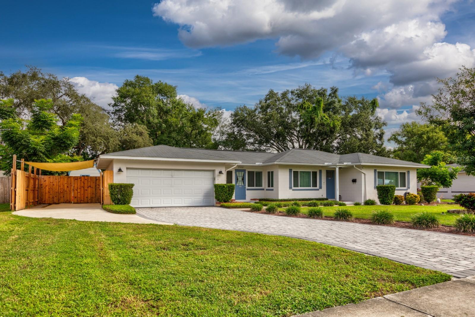 Beautiful home in Mount Dora is thoughtfully upgraded and move-in perfect! Located near Lake Gertrude and Lake Dora, and only minutes from parks, shopping, and dining this home offers both convenience and tranquility. Wide streets, sidewalks, and no city taxes add to the appeal of this peaceful neighborhood. Step inside and feel the difference: gorgeous original red oak floors, electric fireplace for ambiance and the open flow from living room to dining, kitchen and beyond. The kitchen is a standout, featuring soft close cabinetry, high end quartz countertops, sleek stainless appliances with natural gas stove and a layout designed for both function and flair. Whether entertaining or enjoying a quiet morning coffee, this space delivers. Original red oak flooring continues through both bedrooms which share an updated bathroom with tub/shower. Off the kitchen (hidden by sliding door) is a wonderful space currently being used as a family room but could easily be 3rd bedroom/mancave/in-law suite etc., with original Mexican style concrete/tile flooring, its own entrance, adjacent office, remodeled bathroom, and exit to patio and back yard. Outside, the 100x135 lot offers privacy and space to breathe while enjoying the butterflies. A fully fenced yard (2 oversized gates) paver driveway, and 10x12 concrete patio with walkway make outdoor living easy and enjoyable. The 2-car garage with workshop, additional carport, 20x8 shed with loft provide lots of storage and flexibility for hobbies, tools, or toys. New gas hot water heater 2024, energy efficient windows 2021, septic field replaced 2015, see through hurricane shutters all windows, new attic insulation 2022, complete a/c duct work replaced 2022, AC 2015 and roof replaced 2013. Come be a part of the magic everyone is talking about…Mount Dora. Better hurry, this one is SPECIAL!