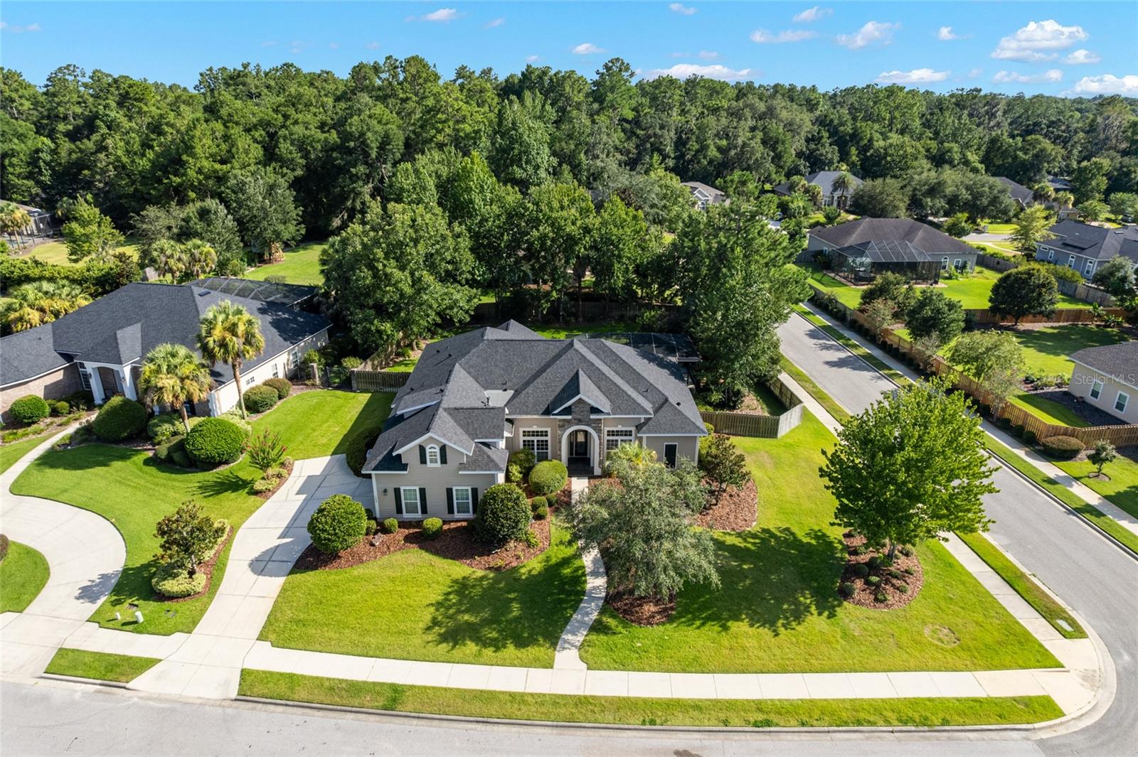 One or more photo(s) has been virtually staged. Welcome to this beautifully maintained 5BR/4.5BA GW Robinson home in the desirable Turnberry Lake community! With almost 3,200 SF of conditioned living space on a .50-acre corner lot, this home offers soaring 10’+ ceilings, an open 3-way split plan, and versatile living areas including a dedicated office and upstairs 5th bedroom/bonus room with full bath. The spacious primary suite features tray ceiling detail, dual walk-in closets, a spa bath, and private French doors to the screened lanai. The spacious kitchen boasts a large center island, subway tile backsplash and newer appliances, opening to the great room with a cozy gas fireplace. Separate formal dining and living rooms provide elegant spaces for entertaining, special occasions, or quiet relaxation, while keeping the great room free for everyday use. Enjoy indoor-outdoor living with French doors leading to the covered lanai with complete screen enclosed heated pool. Recent updates include: roof (2024), carpet (2025), interior paint (2025), exterior paint (2023), water heater (2020), and pool pump (2025). Additional features: 4-zone HVAC (2014), fully fenced backyard, energy-efficient windows, and a 2-car side entry garage. Residents of Turnberry Lake enjoy access to a community pool and playground, miles of neighborhood sidewalks, and a 10-acre private lake for catch-and-release fishing. Located just steps from Jonesville Park, featuring baseball and soccer fields as well as clay tennis courts and just minutes to Tioga Town Center, UF/UF Health and I-75. *Note: Red boundary lines in photos are approximate.