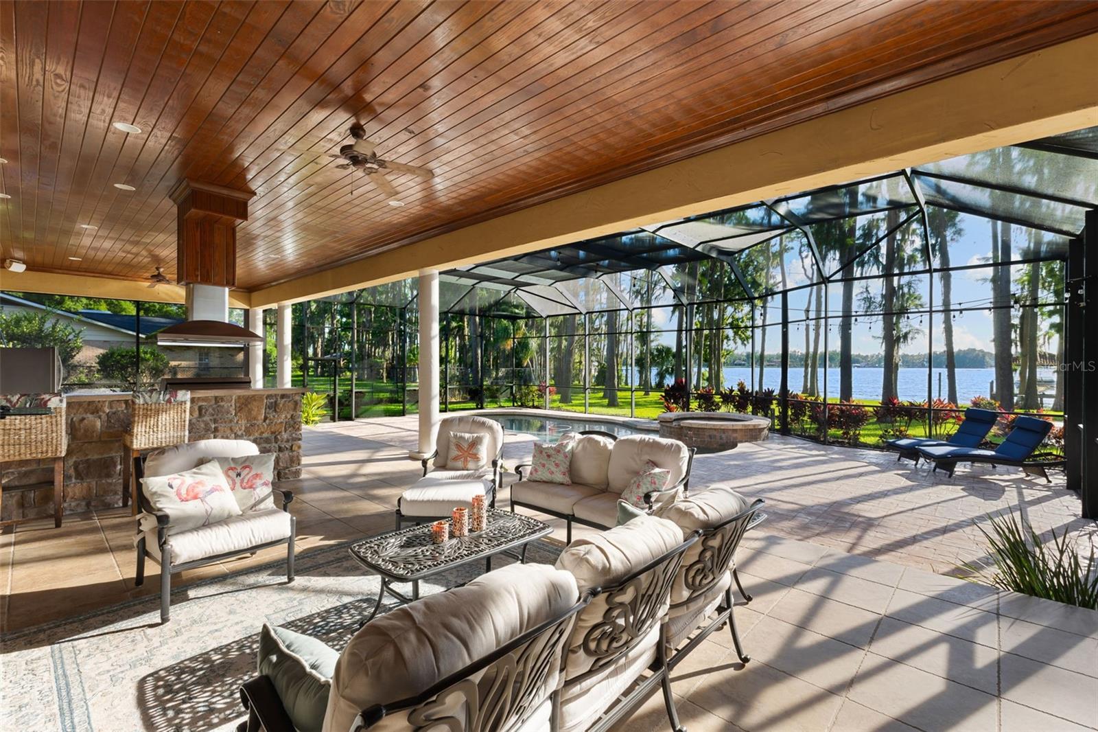 Welcome to this once-in-a-lifetime opportunity to own a breathtaking 2.38-acre gated estate directly on Lake Keystone—Odessa’s most sought after private ski lake. One of only 22 properties on Lake Keystone with over 2 acres of land and western exposure, this remarkable estate offers more than just a home—it delivers a front-row seat to sunsets over the lake every evening. As you enter through the private gate equipped with a brand-new security system, a long private driveway winds its way to the very end of the property—creating an immediate sense of seclusion. The approach reveals a tranquil fountain and a circular roundabout drive that transitions into a paved motor court. This 6,850-square-foot estate showcases 5 spacious bedrooms, 5 full bathrooms, 2 half bathrooms, and a 4-car garage. Step inside and be welcomed by soaring ceilings and views of Lake Keystone. To your left, an elegant formal dining room awaits special gatherings, while to your right, a private guest bedroom and full bath provide comfortable accommodations for visitors. As you move into the heart of the home, the expansive living room and open-concept kitchen take center stage—both with French doors that open to the lanai. Just off the living room, a dedicated game room/bonus room awaits, complete with its own half bath and direct access to the outdoor patio—perfect for entertaining. Discreet pocket sliders lead from the game room into a private home theater. The first floor also includes an office with lake views, a half bath, a temperature-controlled wine cellar, and laundry room. Upstairs, the primary suite is a private retreat featuring its own balcony that overlooks the lake—ideal for morning coffee or taking in evening sunsets. Across the opposite wing, a luxurious guest suite mirrors this experience with a private balcony, full ensuite bathroom, and walk-in closet. A third upstairs guest bedroom also offers its own ensuite bath. For added convenience, a second laundry room is thoughtfully located on the upper level. An expansive in-law suite is thoughtfully positioned on the second level, offering both private access from inside the home and a separate exterior entrance along the side—perfect for multigenerational living or long-term guests. The suite features a generous layout, a full ensuite bathroom, and is pre-plumbed for a future kitchen installation. Step into the backyard and discover over 1,100 square feet of covered outdoor living space—complete with an outdoor kitchen, covered dining area, and an outdoor living room anchored by a fireplace and mounted TV. Beyond the covered lanai, a heated saltwater pool and elevated spa overlook the waters of Lake Keystone, while a path leads to a lakeside firepit and private dock with covered boat slip—offering effortless access to one of Tampa Bay’s premier ski lakes. Situated in Flood Zone X, this estate also features a powerful 40KW whole-house generator for peace of mind—all with no HOA restrictions, offering complete freedom to enjoy your private lakefront home.. Schedule your private showing today!