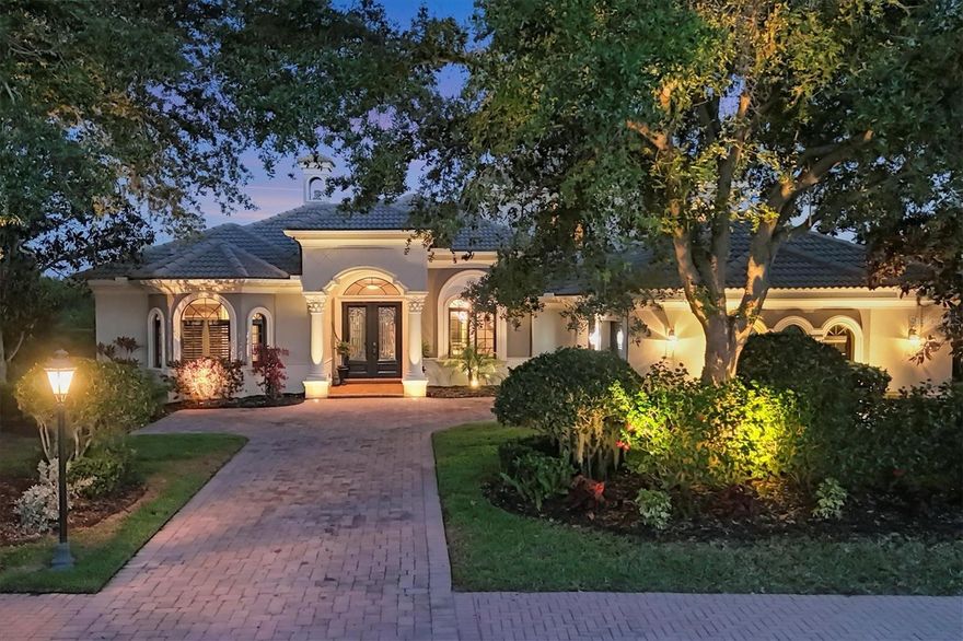 Welcome to luxury living in the exclusive, gated community of The Founders Club, where timeless elegance meets modern sophistication in this beautifully designed estate home. Nestled beneath mature oaks and surrounded by lush landscaping, this stately Todd Johnson custom residence boasts Mediterranean-inspired architecture with exquisite curb appeal and a grand columned entryway. Step through the double glass doors into a meticulously curated interior featuring rich hardwood floors, custom millwork, and soaring ceilings that accentuate the open-concept living spaces. Coffered ceilings, arched doorways, and a beautifully appointed fireplace create a sophisticated yet inviting atmosphere for entertaining. Expansive glass sliders lead you to a serene outdoor haven, featuring a sparkling pool, spa, outdoor kitchen, covered lanai, and a private backyard surrounded by tropical palms and manicured hedges. The gourmet kitchen is a true chef’s dream, complete with high-end stainless steel appliances, a gas range, granite countertops, a spacious center island with seating, and detailed wood cabinetry that exudes warmth and craftsmanship. Just off the kitchen, a cozy breakfast nook provide the perfect setting for casual meals or morning coffee, framed by large windows offering views of the lush outdoor retreat. The primary suite is a sanctuary of elegance and tranquility, blending classic architecture with modern comforts. Bathed in natural light from multiple windows and French doors, this spacious bedroom features a graceful tray ceiling with crown molding and a sparkling crystal chandelier that anchors the room with sophistication. This beautifully appointed home offers a thoughtful and versatile layout, perfect for both everyday living and entertaining. The office/den space is bright and airy, thanks to a trio of large bay windows that offer expansive views of the surrounding landscape and natural light. French doors with glass panes open into the living room, enhancing the sense of openness and connection to the rest of the home. The first floor also features a half bath, as well as private guest room with an adjacent full bath, offering comfort and convenience for visiting friends or extended family. Upstairs, you'll find a spacious bonus room complete with a charming balcony overlooking the pool and garden, that provides endless possibilities as a media room, playroom, or home gym. Two generously sized bedrooms share a well-appointed bathroom, making it an ideal retreat for kids or guests.The Founders Club offers an unparalleled lifestyle surrounded by 700 acres of natural Florida beauty. With just 262 homesites, this low-density enclave is designed for privacy and serenity. Residents enjoy access to a recreation center offering yoga and pilates classes, as well as Har-Tru tennis courts, pickleball, basketball, sand volleyball, and a kid's playground. Membership at the Founders Golf Club is optional offering both golf and social memberships. The renowned Robert Trent Jones Jr. golf course offers members easy tee times and is one of the only walkable courses in the region. Members enjoy a a grand Southern-style clubhouse, fine dining, a year-round social calendar, and a 24/7 fitness facility. It’s more than a home—it’s a lifestyle curated for those who appreciate understated luxury and quiet prestige. All just minutes from exquisite dining, shopping, and the vibrant art scene of downtown Sarasota, as well as Sarasota's incredible beaches.