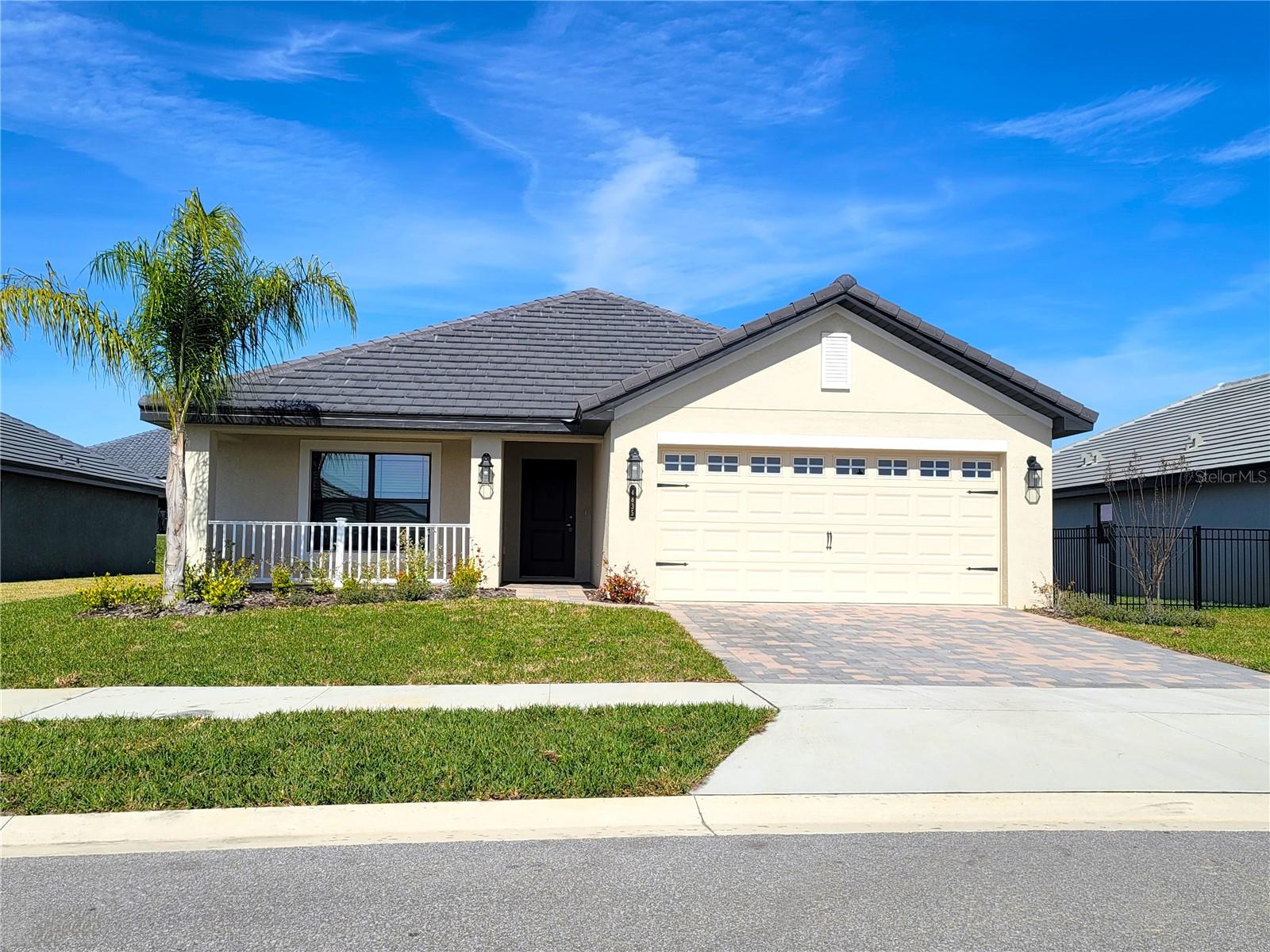 Exquisite, LAKEFRONT GATED COMMUNITY with a ton of amenities, now available! As you come up the paver driveway and walkway you'll come to a covered front porch, perfect for taking in the beautiful sunsets and meeting neighbors. Entering the home, you will immediately notice the wide open floor plan concept that's light and bright with a fresh modern feel. The great room is the center of the home with soaring 10' ceilings, white washed wood plank tile in all common and wet areas, granite countertops throughout, 5 ¼ inch baseboards and surrounded by a private formal dining area with wainscoting; kitchen with a long breakfast bar, stainless appliances, white cabinetry galore; a laundry / pantry room; and a huge dinette area that looks over the large covered back patio and yard. The primary suite is very spacious featuring a tray ceiling. Its private ensuite is nicely appointed with a tall double sink vanity with storage drawers, linen closet, private water closet, tile shower w/glass door, soaking tub and a fantastic walk-in-closet. The other 2 guest rooms are a really good size and share a lovely hall bath and linen closet. This deed restricted community is absolutely stunning and shows off its immaculate landscaping and glorious palm trees as you enter the main gate and down the parkway that leads to the CLUBHOUSE. The private resident amenities include a gathering/billiard room in the clubhouse, a FITNESS center, refreshing beach entry POOL with water features and ample pool furniture overlooking the LAKE, basketball court, pickleball/tennis courts, playground and an exclusive community boat ramp with floating dock along with hammocks to relax in. Where else can you live in a new home with all of this luxury so close to a brand new Publix, I-4 and minutes to Tampa and Orlando? Call today to see this one!