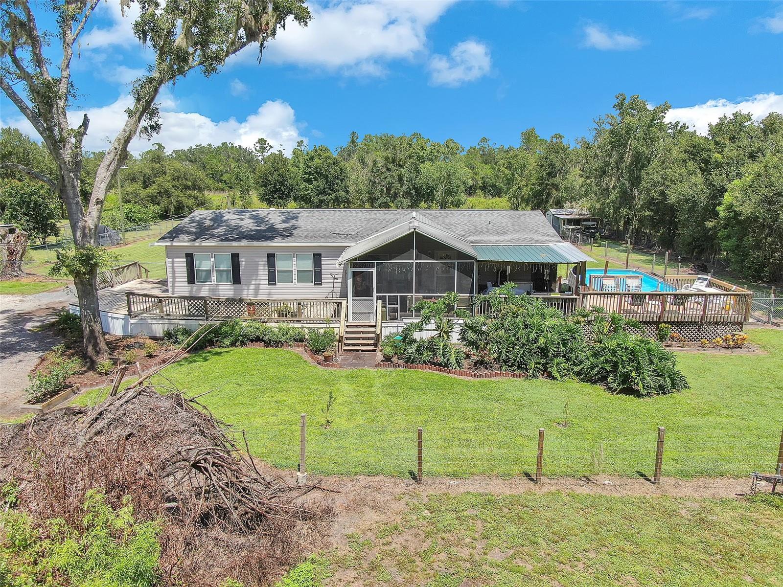 Charming Plant City 3-Bedroom Pool Home on 1 Acre. Welcome to 4936 Steve Reeves Lane—a well-maintained 2001 manufactured 3-bedroom, 2-bath pool home set on 1 acre of land just off Knights Griffin Road. Offering comfort, privacy, and convenience, this home is ideally located to enjoy all that growing Plant City has to offer. The property’s north boundary adjoins the Lower Green Swamp Recreational Area, creating a peaceful natural backdrop. Best of all, the home sits on high, dry ground—no flood insurance is required—providing added security and long-term value. This home has undergone numerous updates, including the installation of granite countertops in the kitchen in 2022, a new water softening system in 2023, and a new air conditioning system in 2025. A spacious deck wraps around three sides of the home, while the fenced pasture area features a 24x26 barn/workshop enclosed on three sides. The pool and outdoor living space provide the perfect setting for entertaining or simply relaxing in your own private retreat. Whether you’re looking for a quiet home surrounded by nature or a practical base with easy access to nearby amenities, this property offers the best of both worlds.