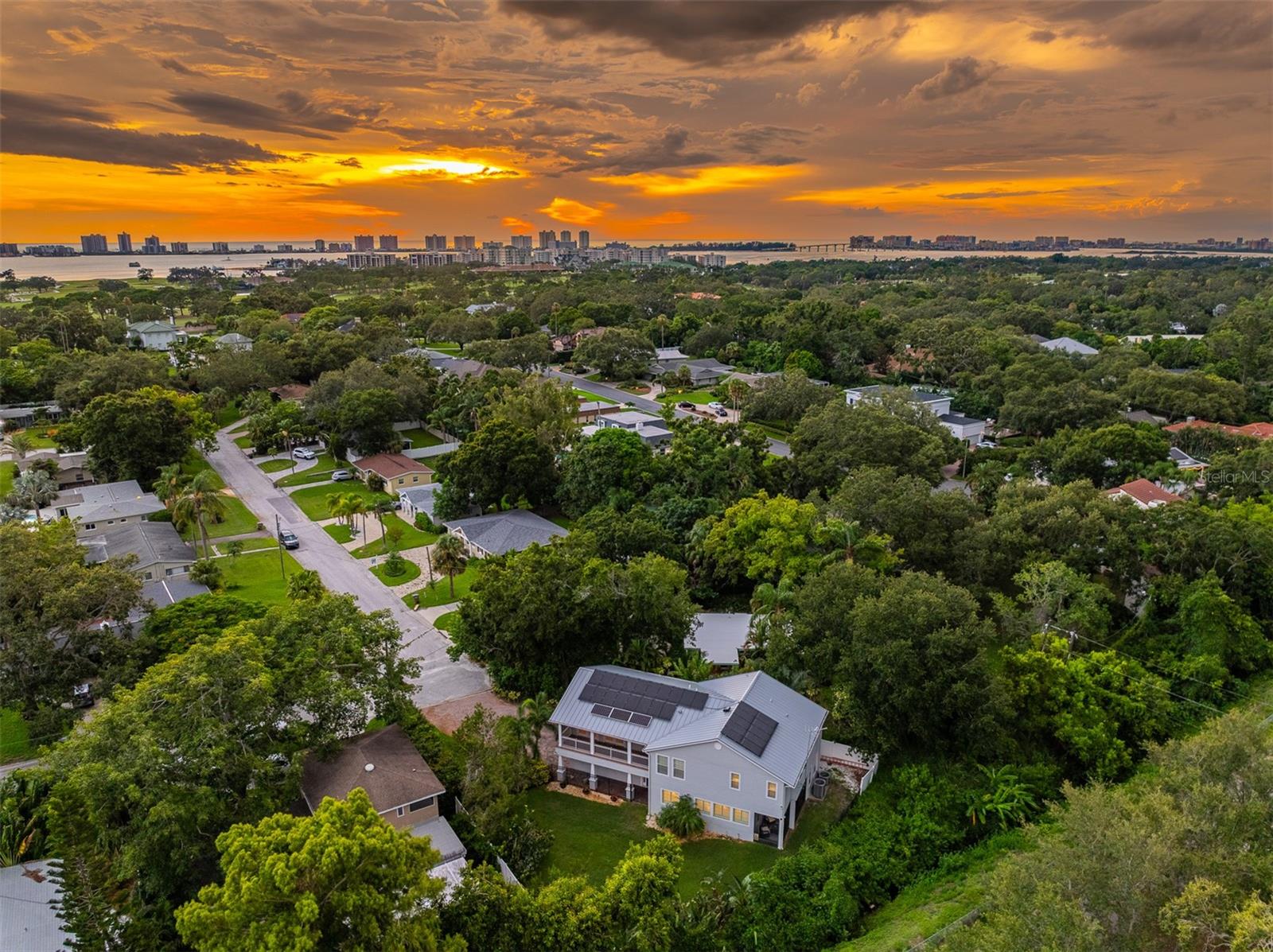 Imagine living in Belleair in this expansive 3 bedroom, 2 1/2 bathroom home (3072 sq ft) nestled at the end of a peaceful cul-de-sac with the Famous Pinellas Trail visible from the backyard surrounded by luscious greenery and many upgrades which include metal roof (2024), roof tied down, 27 solar panels installed (2017) and four more added (2020), solar battery (2020), generator hook up, Two A/C units, 2.5 ton and 4 ton (2018), new toilets throughout (2023/2024), Renai tankless water heater (2024), natural gas stove and natural gas outlet with 50 amp plug to allow natural gas generator to be connected directly to the house, KitchenAid dishwasher (2025) microwave/convection oven (5 years old), Hardie board exterior (for durability and low maintenance), irrigation system upgraded (2024), irrigation well and pump upgraded (2024), added insulation in attic (2015), two screened in patios, one upstairs and one downstairs (2017), LED lights which are motion sensitive, fully fenced in backyard (2013), sprinklers off well and so much more! As you enter the home you will find an inviting living room and dining room area with high ceilings, plantation style shutters and elegant crown molding. Just off the living area is a screened in patio where you can enjoy your morning coffee. Moving to the epicurean kitchen you will find stainless steel appliances, a microwave/convection oven, double sinks, magnetic knife holder next to stove, a breakfast nook and breakfast bar and plenty of room to move around while preparing those delicious meals for years to come. Adjacent to the kitchen is a versatile laundry room that doubles as a butler’s pantry. On this level there is a powder room with a pedestal sink and a toilet. Upstairs the large Primary Suite offers dual walk-in closets, ceiling fan, plantation shutters and the Primary bathroom has a large soaking tub, walk-in shower, granite countertops and dual Kohler sinks. On this level there are two additional bedrooms and a very large bonus room which could be used as an office, kid’s playroom, workout center, media room, or an oversized fourth bedroom offering endless possibilities for customization. Outdoor living is a delight and off this bonus room is a southern facing screened-in porch where you can enjoy a nice book with an ice-cold lemonade or iced tea while overlooking the grassy yard. With a fully fenced backyard, a two-car garage, and additional storage space, gutter leaf filter, this home is ready to welcome you. All of this and more for under a million! Possible, partial seller financing, ask for details. Schedule a private showing today and experience the charm of Belleair living.