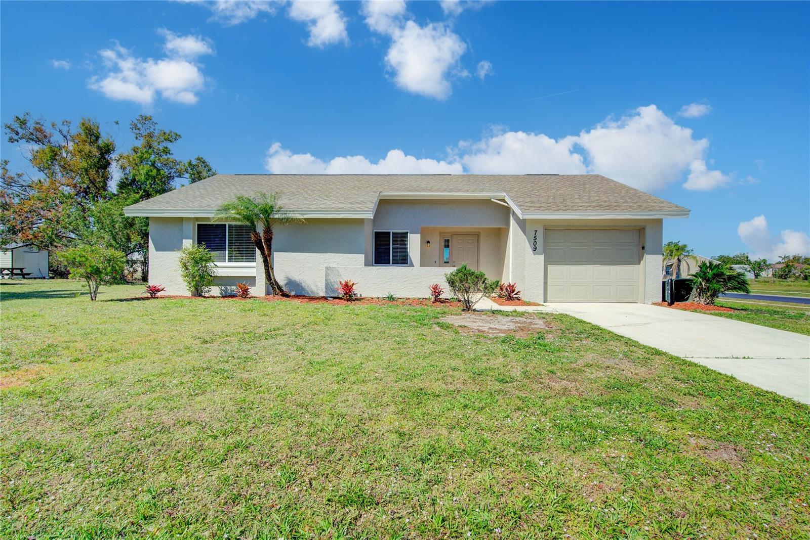 This updated home offers a functional layout with modern finishes, including updated flooring, neutral paint tones, and large windows that bring in natural light. The kitchen and living areas provide a seamless flow, leading to a screened-in lanai that extends the living space and overlooks a spacious yard. Both bathrooms have been fully renovated, featuring marble countertops, custom sinks, and barn-style shower doors. Across the street, Highland Ridge Park offers six pickleball courts, tennis and racquetball courts, basketball courts, shuffleboard, a playground, and a rentable pavilion with a grill and electricity. Conveniently located, this home provides easy access to outdoor recreation, local conveniences, and popular destinations, including Warm Mineral Springs Park (10 minutes), CoolToday Park (20 minutes), and Manasota Key Beach (30 minutes).