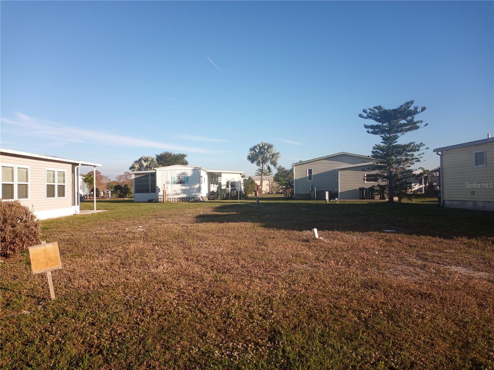 PET FRIENDLY HOMESITE on a quiet cul-de-sac in Holiday Park; one of North Port's most sought after communities. Put a brand new manufactured home on this non-flood zone property that is already connected to electricity, water and sewer. There are NO HOA or CDD fees. Holiday Park is a LAND OWNED, DEEDED community with a monthly maintenance charge of $195 ($2340.00 a year which is included in your tax bill). The community features two clubhouses, two swimming pools, a library, a fitness center, tennis, pickleball & bocce ball courts. You’ll also find billiards, shuffleboard, horseshoe pits, ping pong tables, a card room, dart boards and lots of social activities.