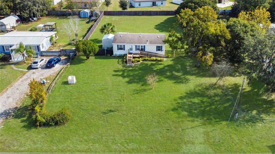 Finally, a cute 3/2 home option with no HOA, a beautiful 1/2 acre lot & in move-in ready condition! This sprawling lot is nice and level with a fenced backyard. Low-maintenance bahia grass is ideal in Florida and plays well with the climate, which means no high water bills trying to keep it alive! This accessible home has both stairs and an entry ramp to the front and rear door. Inside the home opens into a large great room with the kitchen facing the backyard. This open concept feels spacious and bright with luxury vinyl plank throughout! A breakfast bar/island is a great spot to hang out and eat along with the nook that accommodates your table and chairs. The cabinets are plentiful in a neutral wood with new countertops. The laundry room sits o? to the left with additional storage and access to the backyard. All appliances convey. The primary suite overlooks the front yard with a private bathroom and walk in closet. The two additional bedrooms share a full bath and linen closet. The backyard also has additional storage with an 11x12 metal building and a covered work area. Truly a fantastic piece of property where you can continue to grow whether you decide to add on to the house, add a pool, or finally get some chickens!  Located in Leesburg in beautiful Lake County, bring your boat or jet skis and enjoy one of the many lakes on the nearby Harris Chain, including Lake Harris, Lake Griffin, and Lake Eustis.  Whether you’re into boating or fishing, you’ll love the ability to visit different cities and even access the intracoastal waterway! Another luxury to being nestled in the center of the state, you’re just 2 hours to either Florida Coast!