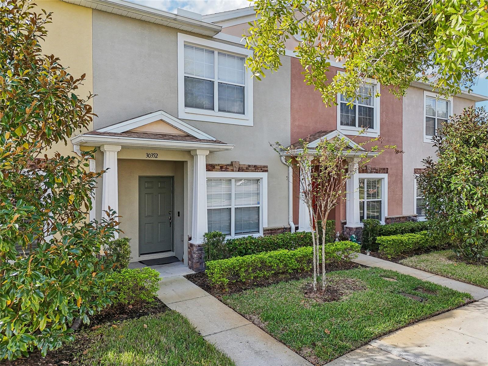 Welcome to this beautiful and spacious townhome located in the gated Hillhurst Crossing community, within the highly sought-after Meadow Pointe neighborhood. Situated on a premium waterfront lot, this solid block-constructed home remained completely unaffected during Hurricane Milton—no damage, no flooding, and not even a power outage! The updated eat-in kitchen features solid oak cabinetry, stainless steel appliances, and a generous pantry. The expansive living room boasts brand new luxury plank vinyl flooring and includes a dining area that flows seamlessly into a versatile office or den space. Upstairs, you'll find two large master suites, each with its own private ensuite bathroom (one featuring a dual vanity) and ample closet space. A spacious bonus room separates the two bedrooms, ideal for a home office, playroom, or additional lounge area. Enjoy peaceful pond views from the screened-in lanai, which also includes a convenient storage closet. Community amenities include a gated entrance, swimming pool, tennis and basketball courts, clubhouse, fitness center, and a play area. Located in a top-rated school district, this townhome offers quick access to I-75, USF, downtown Tampa, Wiregrass Mall, Tampa Premium Outlets, Advent Hospital, Moffitt Cancer Center, and more. Includes two assigned parking spaces plus ample guest parking. Don't miss out on this exceptional opportunity!