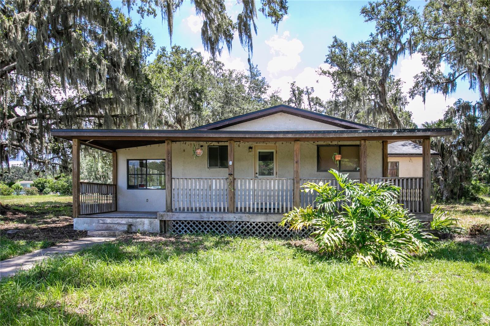 Bring Your Vision – 5.78 Acres with Pond & Country Privacy.
If you’ve been searching for land, privacy, and a place you can truly make your own, this 3-bedroom, 2-bath home with a screened-in pool sits on 5.78 acres and is ready for your ideas. The bones are here—vaulted ceilings, a dramatic stone fireplace, an updated kitchen, a bonus room, and even a newer bathroom—but it’s time for some TLC to bring it back to life.
You’ll enjoy your own private pond and a 2,000 sq. ft. barn that’s ready for a full makeover—perfect for those who see potential in restoring or repurposing it. There’s also plenty of open space for boats, RVs, animals, or any project you’ve been dreaming about—no HOA to tell you otherwise. The screened pool area includes a pool house/laundry room, and the patio is just waiting for sunny-day BBQs.
Set in a peaceful country setting yet only 20 minutes from Mount Dora, Tavares, and Eustis, this property offers the rare chance to create your dream estate or mini-farm exactly the way you want it. Whether you renovate and restore or reimagine from the ground up, the possibilities are as wide open as the land itself.
