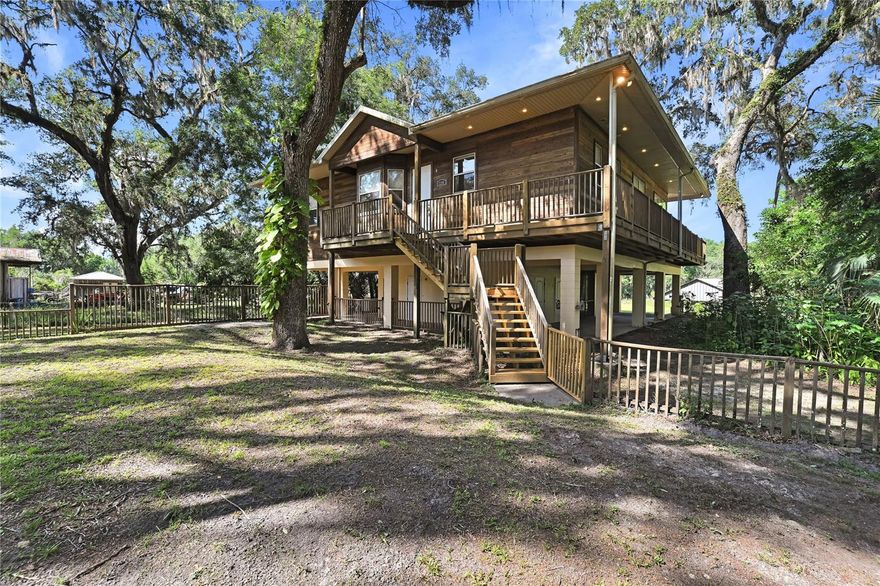 Nestled at the secluded end of a quiet street along the tranquil banks of the Withlacoochee River, this high and dry retreat is a rare find indeed. Nature lovers will adore the serene 1.53 acres shaded by mature oaks, perfect for wildlife, boating, fishing, or kayaking. You will own 366ft of the shoreline, a private dock and boathouse with its own ramp.
Recent updates include a new roof (2025), 3 zone A/C (2018) ensuring lasting quality.
A 25kw automatic generator and in ground propane storage allows you to be self-sufficient
during bad weather. Outdoor living is equally spectacular, with side decks and a newly updated
dock perfect for serene evening views. Parking is effortless with 4 carport spaces providing room for
all your vehicles and toys.
Designed for relaxation and functionality, this 2 story home boasts a safe room with re-enforced
construction on the 1st floor that is also living space! Perfect for a daybed, exercise room or man
cave. It opens up to a screened room off the back of the home just the right size for a hot tub.
Also included is a built in custom wood sauna. Access to the upstairs via the glass surrounded
stairway or the custom built elevator, takes you into the living room. This is the heart of the
home—whether you are watching a game, curling up by the fire, or simply taking in the peaceful
surroundings. Step inside the expansive 2,400+sqft of timeless architecture, all enhanced by modern
luxuries. Glass sliding doors provides breathtaking views of the surrounding wildlife and river,
while 10ft ceilings and skylights flood the home with natural light. Shades in the rooms ensure your comfort and privacy. A stunning fireplace adds warmth and charm, allowing you to enjoy its glow from both the living room and the kitchen.
The dining room, situated between the living area and kitchen, features a river view, seamlessly
blending indoor and outdoor entertaining. The kitchen is a chef’s delight, offering wood cabinetry and plenty of prep and storage space. It blends elegance and functionality with newer stainless steel appliances including: 5 burner gas cooktop, electric double built in ovens (1
convection). Jenn-Air side by side refrigerator and Trash compactor.
The expansive master serves as a true retreat, complete with its own cozy office or library
behind glass French doors offering ample space to unwind. The beautifully updated ensuite bathroom
boasts a separate shower and modern vanities. A spacious second bedroom also offers direct deck
access and large closets. The 2nd bath offers its own updated glass vessel sink and a modern walk-in shower with
decorative tile. The 3rd bedroom contains a Murphy bed and can easily serve as an office/ hobby
room for everyday use and a comfortable guest room when needed.
Authentic Florida living awaits outdoors, where you can enjoy panoramic river views or utilize the
massive dock/ boathouse for launching a kayak, fishing, or simply taking in the beauty of the river. Furnishings available
Whether you are seeking a full-time residence, a weekend escape, or an investment opportunity for
Airbnb, this riverfront paradise delivers the perfect mix of privacy, comfort, and outdoor enjoyment.
Experience the magic of waterfront living—schedule your private tour today.
(a complete list of features available in realtor attachments)