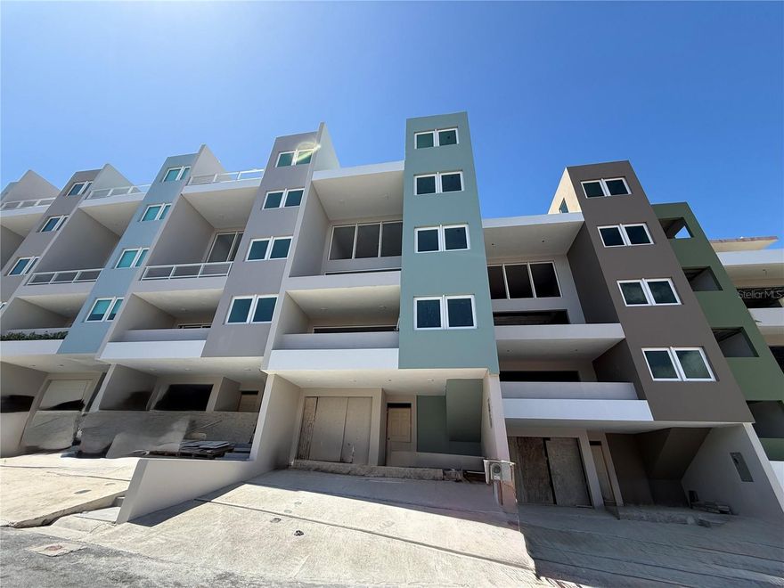 One or more photo(s) has been virtually staged. Under Construction. Welcome to Breeze Point at Shell Castle Club, Palmas del Mar. Located on a quiet cul-de-sac, this newly built residence offers privacy and panoramic views of the ocean, marina, resort, and El Yunque Rainforest.
With approximately 4,271 sq ft across five levels, the home features 5 bedrooms and 6 bathrooms, designed for comfortable living and entertaining. Bright, open interiors connect seamlessly with multiple balconies and outdoor spaces.
The layout includes a 2-car garage with golf cart space, pool area, a secondary master suite with additional bedrooms, a main living level with kitchen and balconies, a private primary suite with spa-style bath, and a rooftop terrace with theater room and office.
Additional features include a private elevator, high-quality windows and sliding doors, and outdoor areas with pool, patio, and BBQ space.
Set on a 159 sqm lot, this modern townhome is ideal as a primary residence or vacation property.
Palmas del Mar offers golf, tennis, pickleball, marina, Yacht Club, equestrian center, The Palmas Academy, dining, shopping, and more—all accessible by golf cart.
Estimated completion: End of 2026. Renderings shown; final finishes may vary.