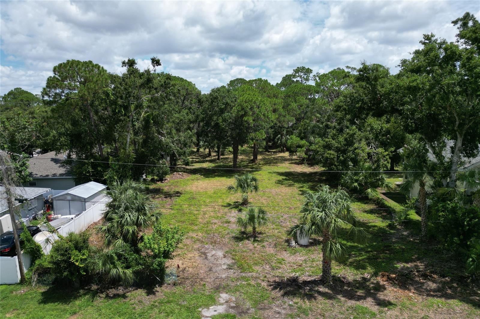 Rare Oversized Residential Lot Adjacent to Lime Lake Park – North Sarasota. Discover a unique opportunity to own a generously sized residential lot in North Sarasota, tucked away on a quiet street and bordered by the natural beauty of Lime Lake Park. This mostly cleared parcel features a scattering of mature trees, level terrain, and convenient access via 21st Street. Ideal for both investors and those looking to build a custom home in a peaceful neighborhood, this lot offers versatility and value in one of Sarasota’s up-and-coming areas.
There is an old water well located near the front of the property, as evidenced by the old pump and holding tank. The well and equipment have not been tested or inspected, and the condition or functionality of the well is unknown.
The lot to the North is being sold separately if interested in doubling the size of your property.
Please note: This parcel was recently subdivided from a larger 0.62-acre lot and may not yet be accurately reflected on County maps. This property includes a 20-foot easement along the eastern property line to allow access to the parcel to the North. For a visual representation of how this lot could be laid out after development, take a look at the property immediately to the East (2425 21 St St) and the property directly across the street (2410 21 St St). Both were divided in a similar fashion.