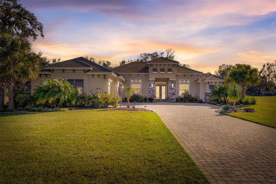 This must-see, custom-built Olsen home in Liberty Village is a rare opportunity for luxurious lakefront living. Nestled on 3.3 meticulously landscaped acres across three premium lots, this state-of-the-art smart home at 2354 Legacy Lane offers breathtaking water and conservation views. Step into an open floor plan featuring 12' coffered ceilings, floor-to-ceiling pocket sliders, and a stunning lanai with a heated pool/spa, all overlooking your private lake with a tranquil fountain. The gourmet kitchen is a chef’s dream with luxury appliances, soft-close wood cabinetry, a walk-in pantry, and elegant leathered granite countertops. The owner’s suite is a retreat of its own with double walk-in closets, dual vanities, a soaking tub, and a walk-in shower with dual shower heads. Guests will love their private bedroom with an ensuite bath, while a private office with custom barn doors offers flexibility as a fourth bedroom. Additional highlights include a wet bar with a wine cooler, a large laundry room, 3-car garage, Low-E impact-resistant windows, full-home generator, and an elegant paver driveway. Minutes from I-95, New Smyrna Beach, Flagler Avenue, and historic Canal Street, this home blends high-end living with every imaginable luxury. Don’t miss your chance to make this stunning estate your private oasis!