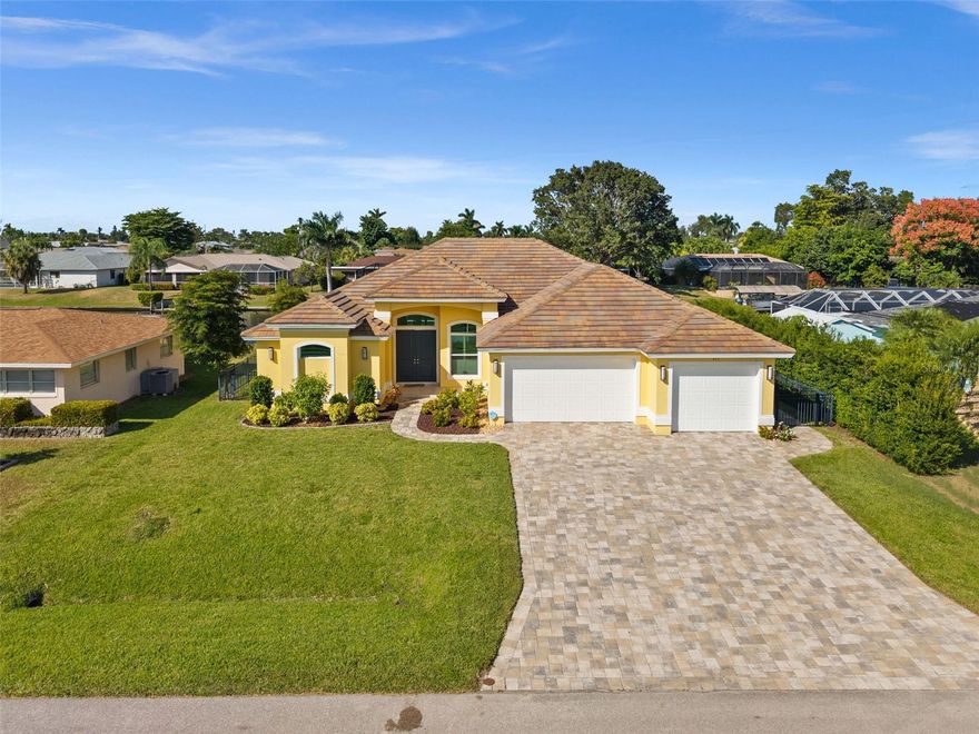 Welcome to this beautifully maintained Gulf Access home, built in 2017 by the builder Latitude 26 on a 100-foot-wide canal, just a short bike ride from downtown Cape Coral. This 4-bedroom, 2.5-bath residence offers nearly 2,300 square feet of living space designed for comfort and coastal living. The spacious great room features high tray ceilings and a full wall of sliders opening to the screened lanai and heated pool, perfect for relaxing or entertaining. The kitchen features dual islands, granite countertops, a tile backsplash, stainless appliances, a breakfast bar, and a coffee bar. The primary suite includes a tray ceiling, sliding doors to the pool area, a walk-in closet, and a luxurious bath with separate vanities, a soaking tub, and a glass-enclosed shower. Tile floors run throughout the home, adding to the clean, modern feel. Outside, enjoy the Florida lifestyle with an outdoor kitchen installed in 2024, covered lanai, and a beautiful composite dock with a full-width captain’s walk and a 10,000 lb covered boat lift. The oversized 3-car garage, paver driveway, tile roof, security system and Impact windows and doors complete the package. Located on a quiet street, this home offers easy access to boating, beaches, and waterfront dining. THIS HOME HAS NEVER FLOODED!