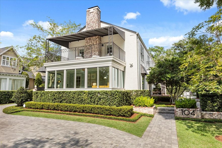 Commanding an elevated position with tranquil views of Lake Mizell, this quintessential 1926 estate artfully fuses period elegance with refined, modern enhancements. Moments from the boutiques and restaurants of Park Avenue, the residence welcomes with a paver circular drive and a private, gated side entry leading to a detached two-car garage. A brick-clad front porch and mature landscaping frame the formal entry, setting a tone of architectural distinction. Inside, a gallery-style foyer showcases designer wallpaper and salvaged pew rail detailing from a New York City church. The formal living room offers a stately gas fireplace, bespoke built-ins, and a large fixed window framing the lake, ideally suited for a quiet reading nook. The adjacent sunroom, encased in fixed glass, captures the surrounding canopy and lake vistas in all seasons. A generous dining room with custom dry bar, underlit floating shelving, and beverage refrigeration provides an ideal setting for elegant entertaining. The gourmet kitchen is thoughtfully appointed with paneled appliances including refrigerator and freezer columns, refrigerator drawers and a microwave drawer. Additional features include natural gas cooking, double ovens, and a sun-drenched breakfast room opening to the rear terrace and lap pool. A Dutch door entry offers functional access for daily living, while the basement below presents an opportunity for climate-controlled wine storage. The upstairs primary suite exudes comfort and sophistication with its gas fireplace, walk-in closet illuminated by a lake-facing window, a private covered balcony, and a spa-inspired bath with dual vanities, soaking tub, steam shower and private water closet. Two additional guest rooms with a Jack and Jill bath complete the upper level. Extensive renovations include a newer roof, Andersen windows and doors, two HVAC systems, full re-piping and rewiring, fresh paint, lighting, a newly installed pool heater and Hardie board siding—all executed within the last five years. The walk-up attic and pristine basement offer rare additional storage. Refinished hardwood floors throughout provide a consistent, elegant backdrop. This residence is a compelling blend of character, craftsmanship and contemporary living.