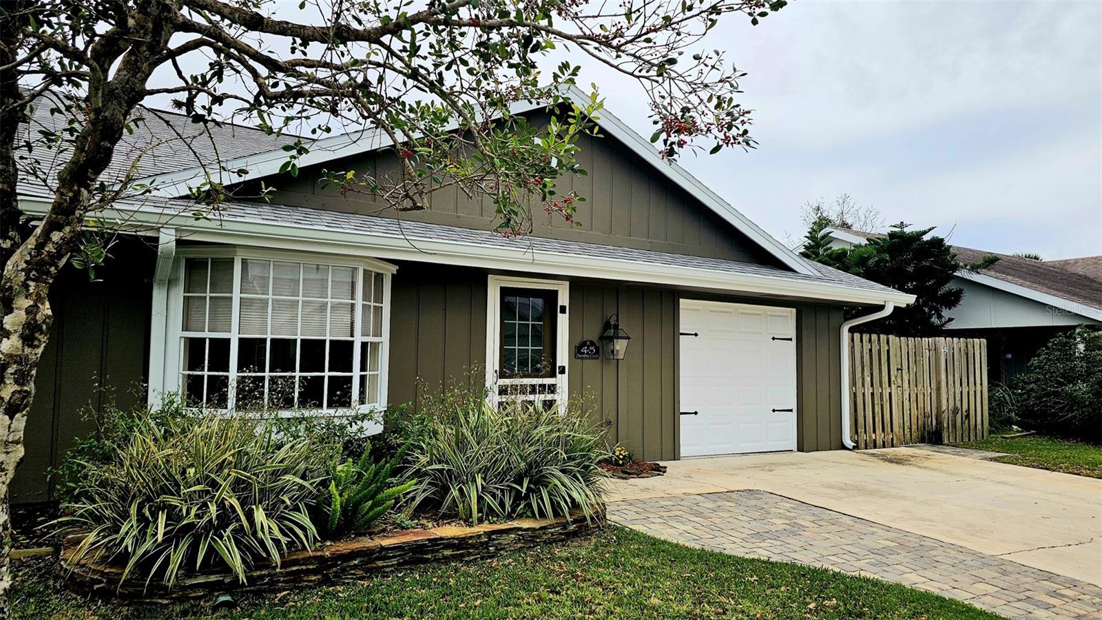 Updated golf villa with Brand New ROOF in January 2025 and New AC 2024. Engineered wood floors throughout living area and bedrooms, and luxury waterproof vinyl in bathrooms and kitchen. Updated bathroom cabinets, faucets and countertops. Kitchen has been opened up to become part of the living area, with granite counters and extra seating at bar area. Newer SS kitchen appliances - 4 to 5 years young, dishwasher 2023. Vaulted ceiling in living/dining area and bay window. Spacious garage with lots of natural light, storm rated door, and storage closet housing 50 gallon water heater. Interior laundry with full-size W/D. Spacious Florida Room with window AC units provides additional 170 sq. ft. of living space, and leads to patio area for covered outdoor space. Large storage area/workshop is the perfect man-cave or hobby area. Beautiful backyard with zero landscaping and no lawn to maintain is perfect spot for entertaining, grabbing some rays or getting away from the rest of the world. Side yard has electric awning with drop-down sunscreen for additional outdoor living space. Ample side-by-side parking on driveway, as well as garage parking. Golf cart friendly community, ride your golf cart to Hidden Lakes Golf Club clubhouse/restaurant, or Municipal Golf Course/Restaurant. Nestled between 2 golf courses and near the Historic Canal Street shopping district. Eclectic Flagler Avenue shops and dining venues are but a few minutes away by car, as is the beach! Low annual HOA fees provide termite bond and irrigation system and water for sprinklers. Community heated pool/spa, available by optional and separate membership to Pool Association.